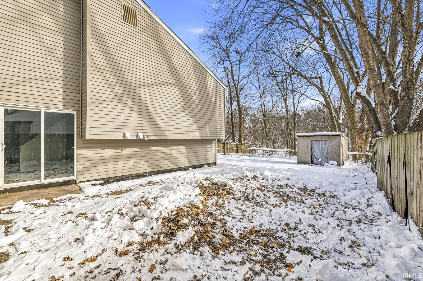 View of snow covered exterior featuring a shed