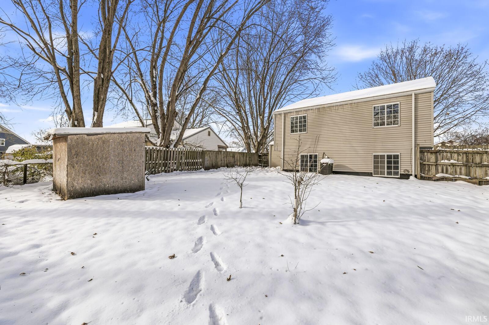 View of snow covered back of property
