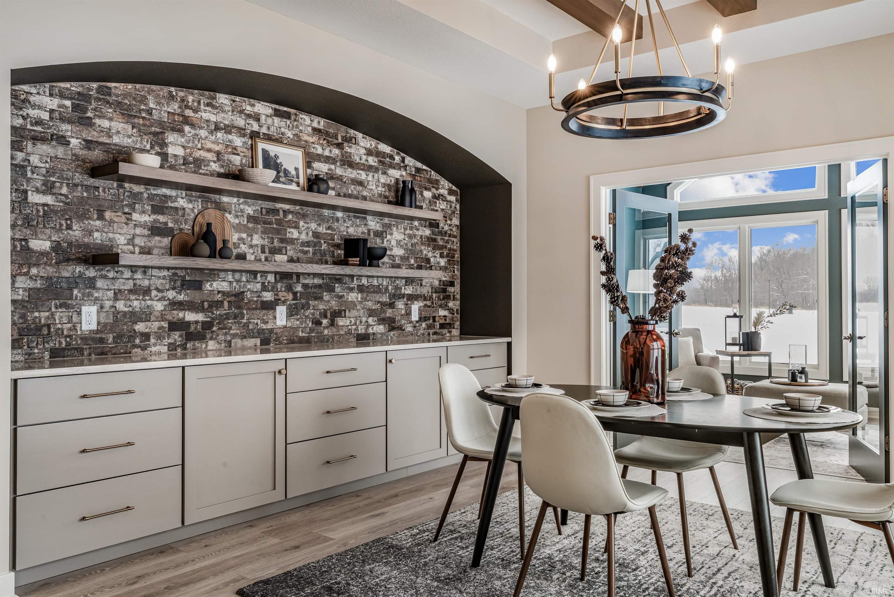 Dining space with light wood-style floors and brick wall