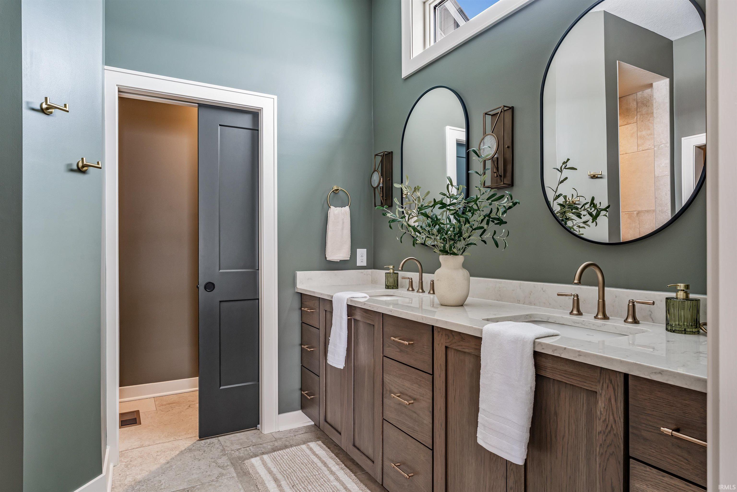 Full bathroom featuring double vanity and baseboards