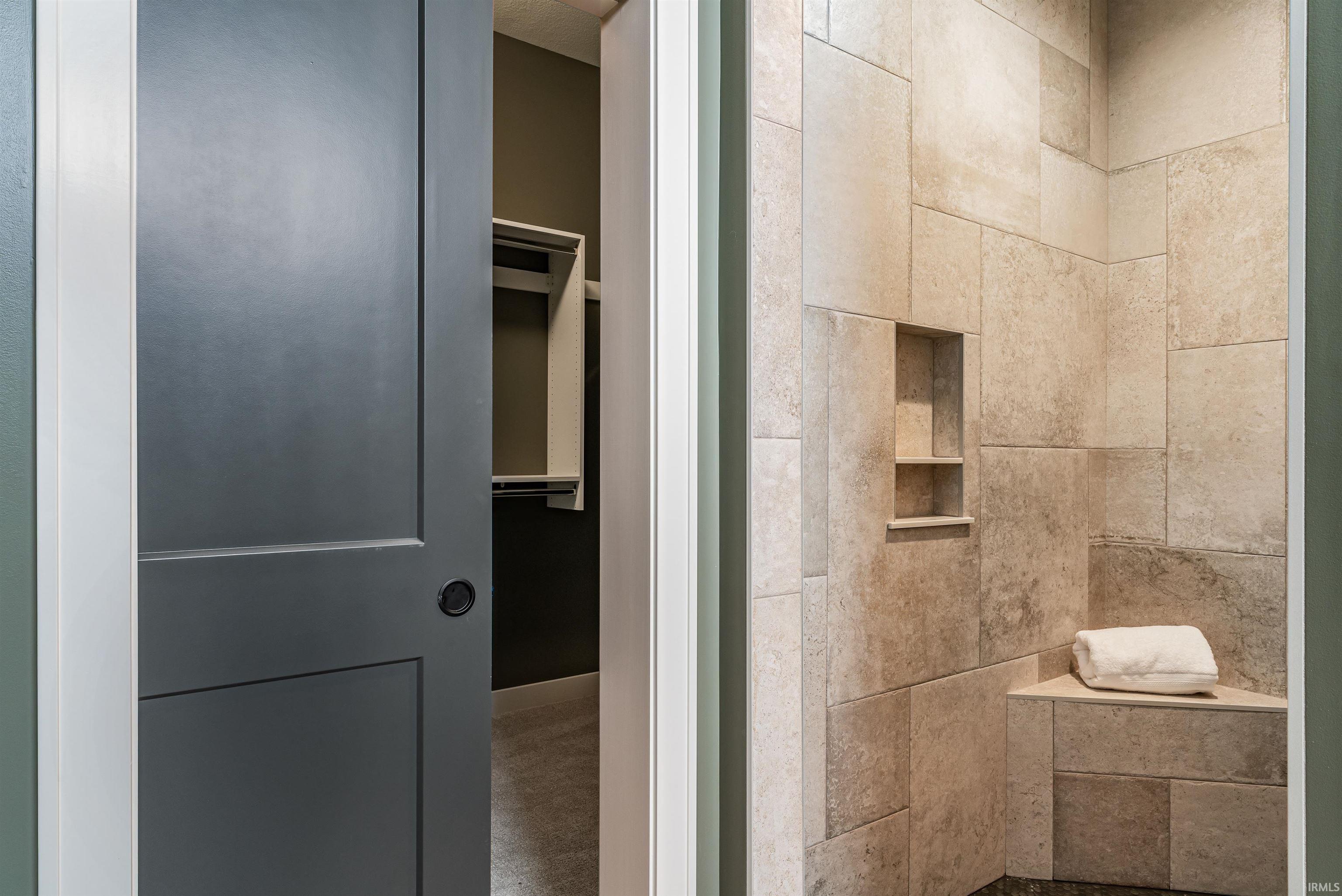 Full bath with a spacious closet and tiled shower