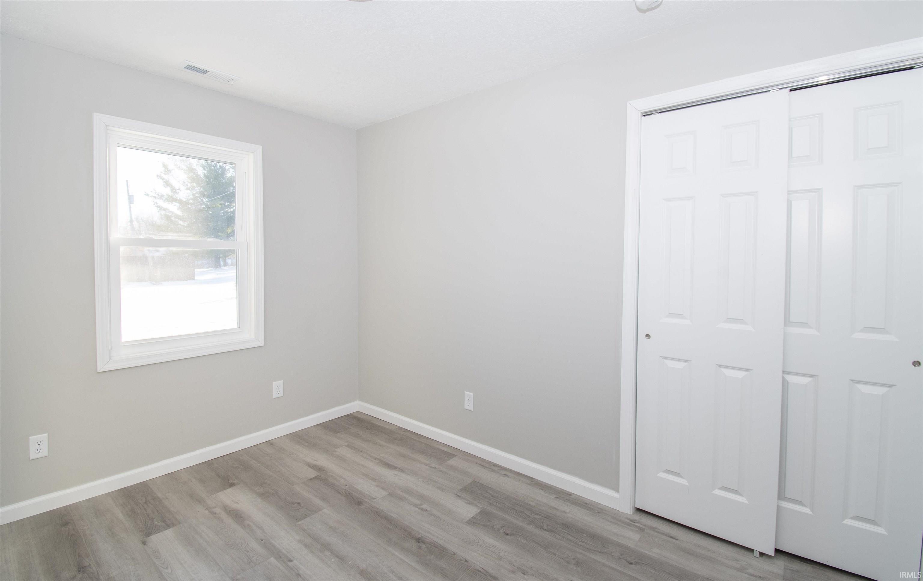 Unfurnished bedroom with light wood-style flooring and a closet