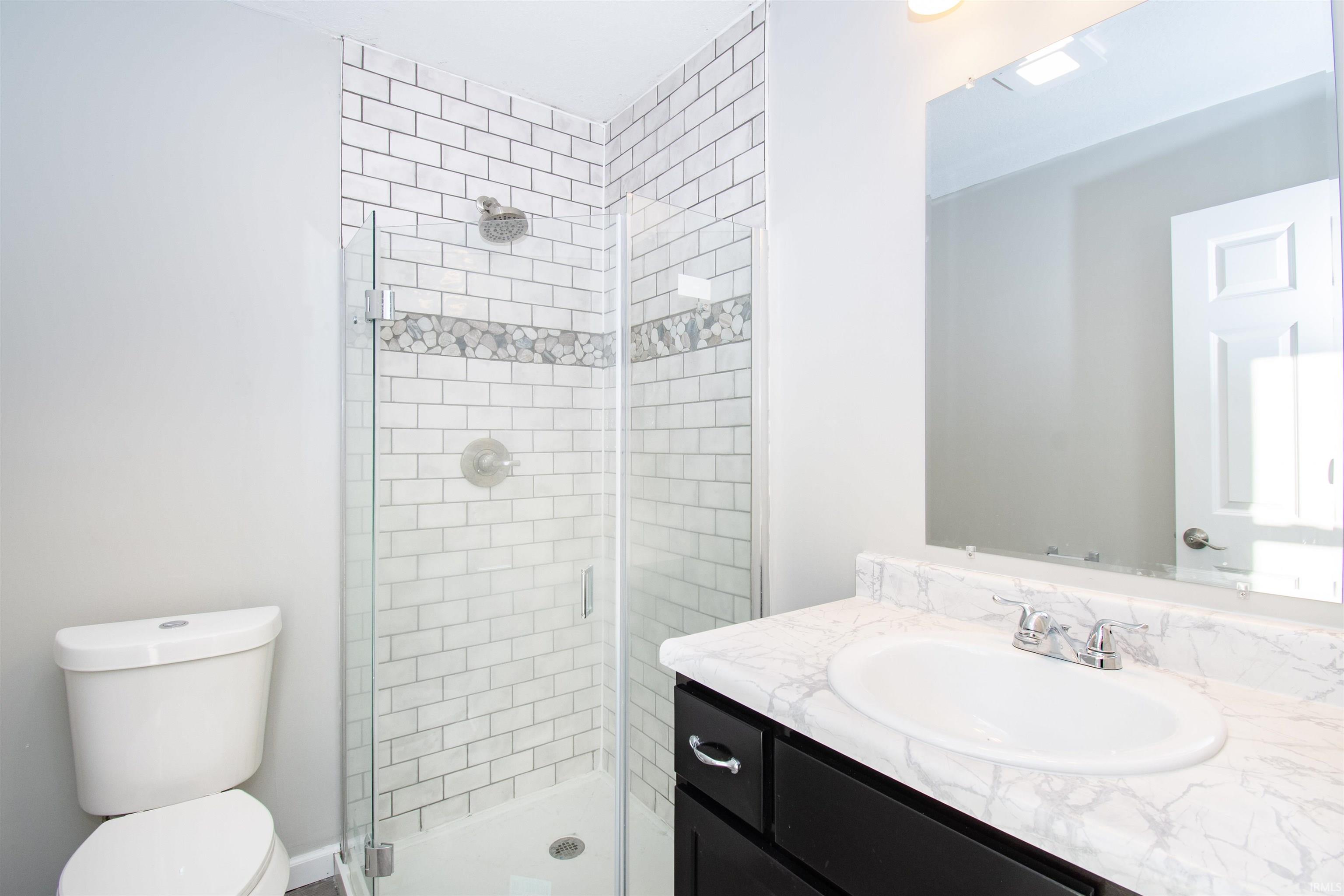 Full bath with vanity and a shower stall