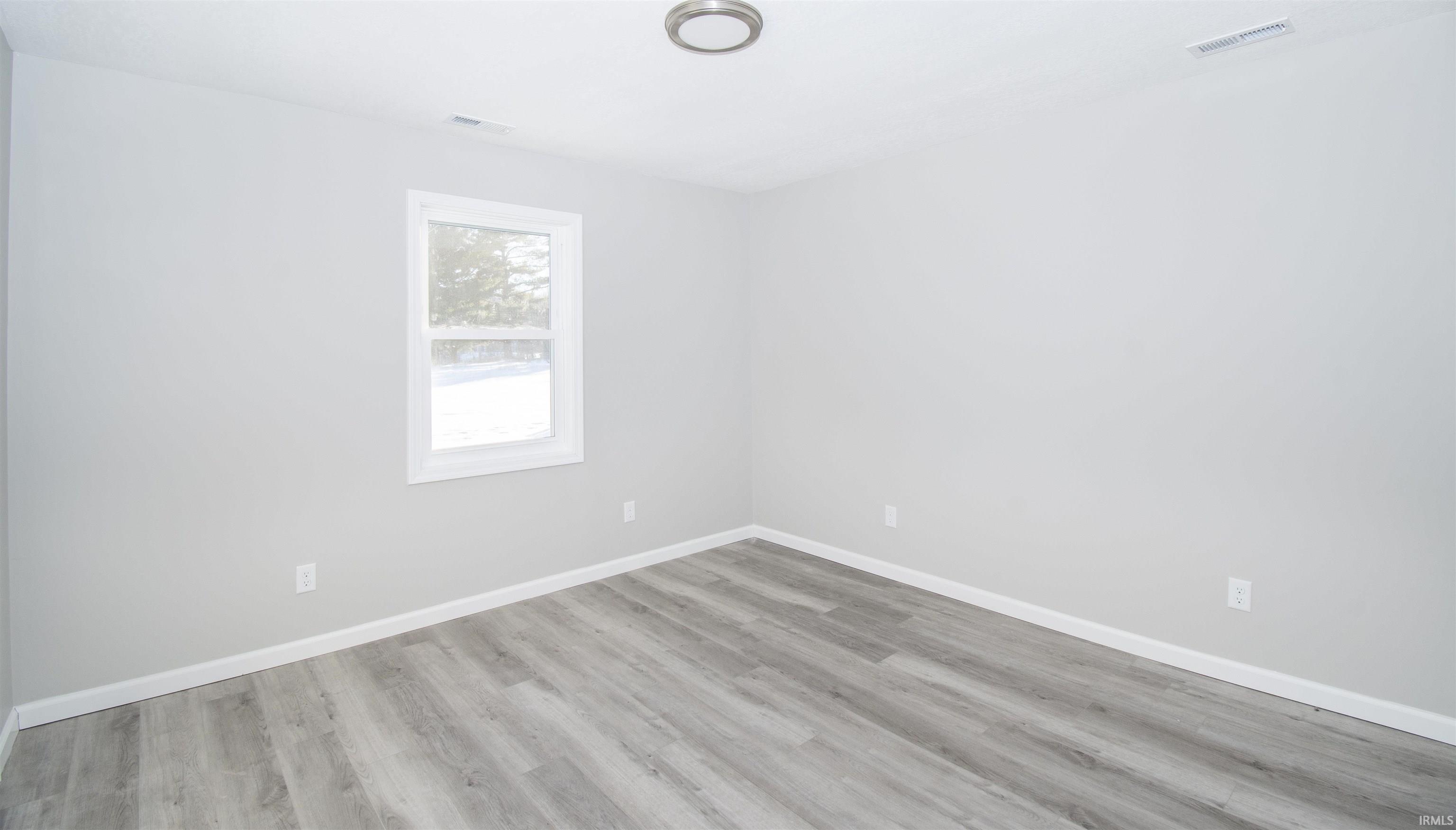 Empty room with baseboards and light wood-style floors