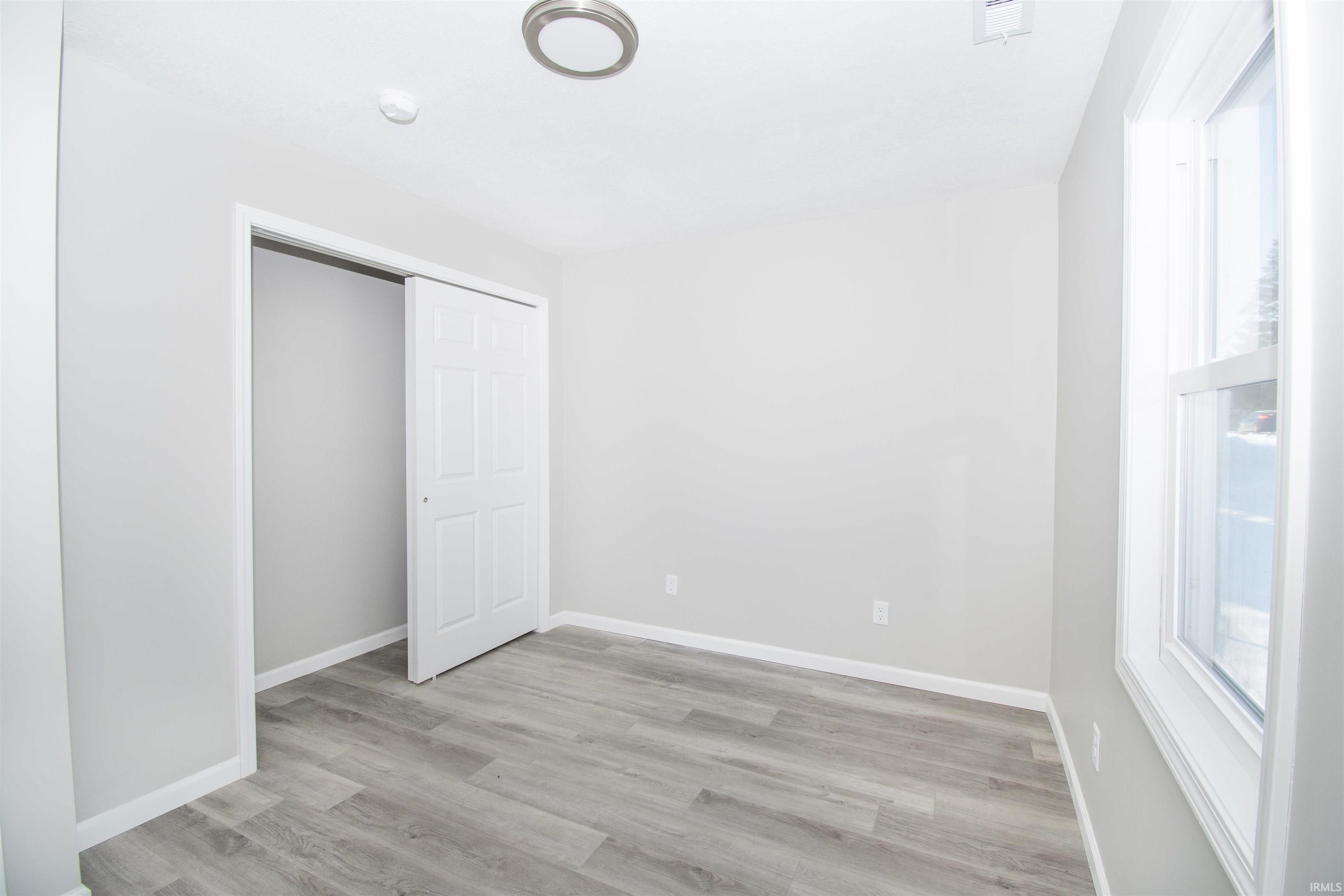 Unfurnished bedroom with light wood finished floors and a closet