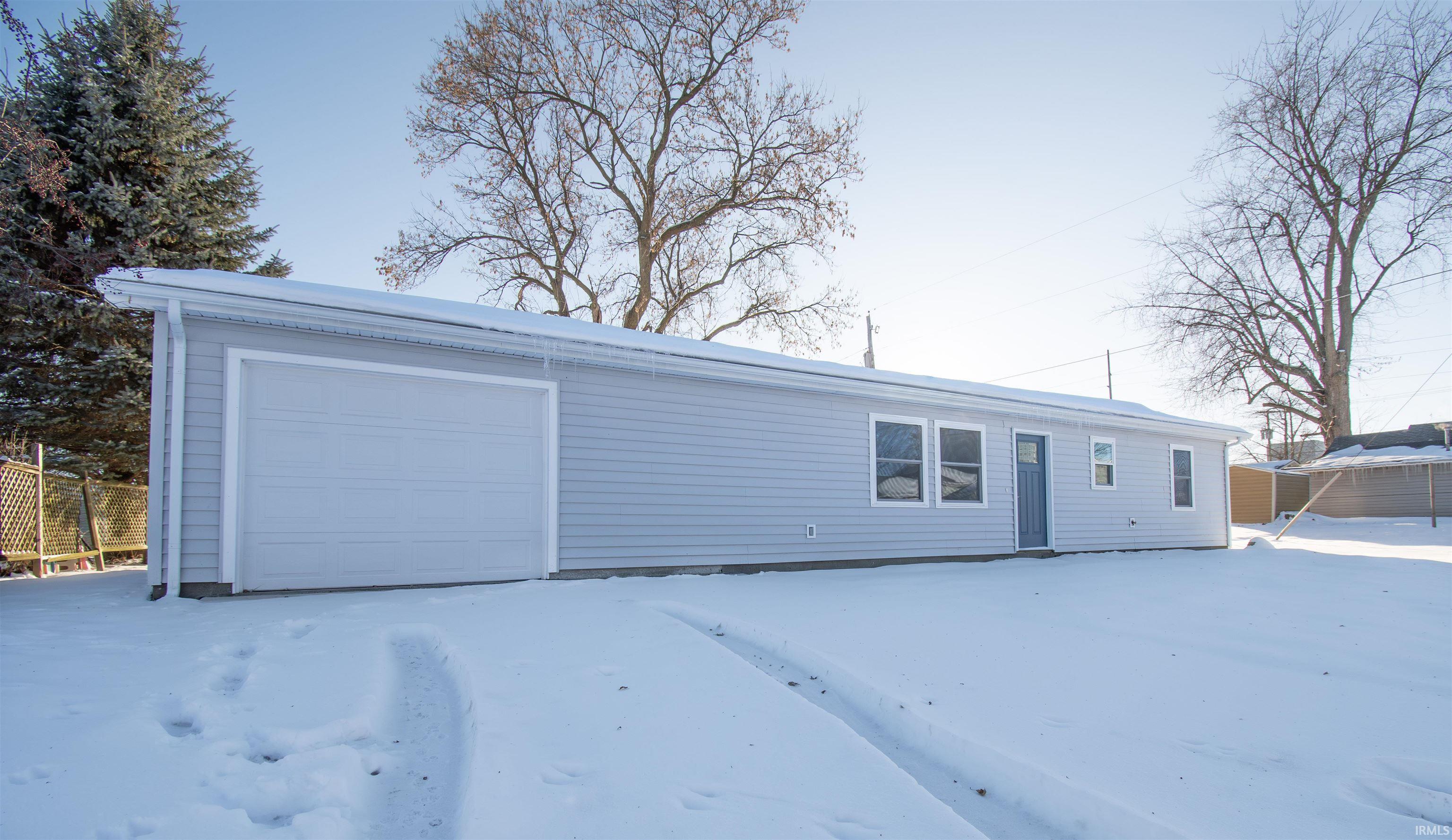 Ranch-style home with a garage and an outbuilding