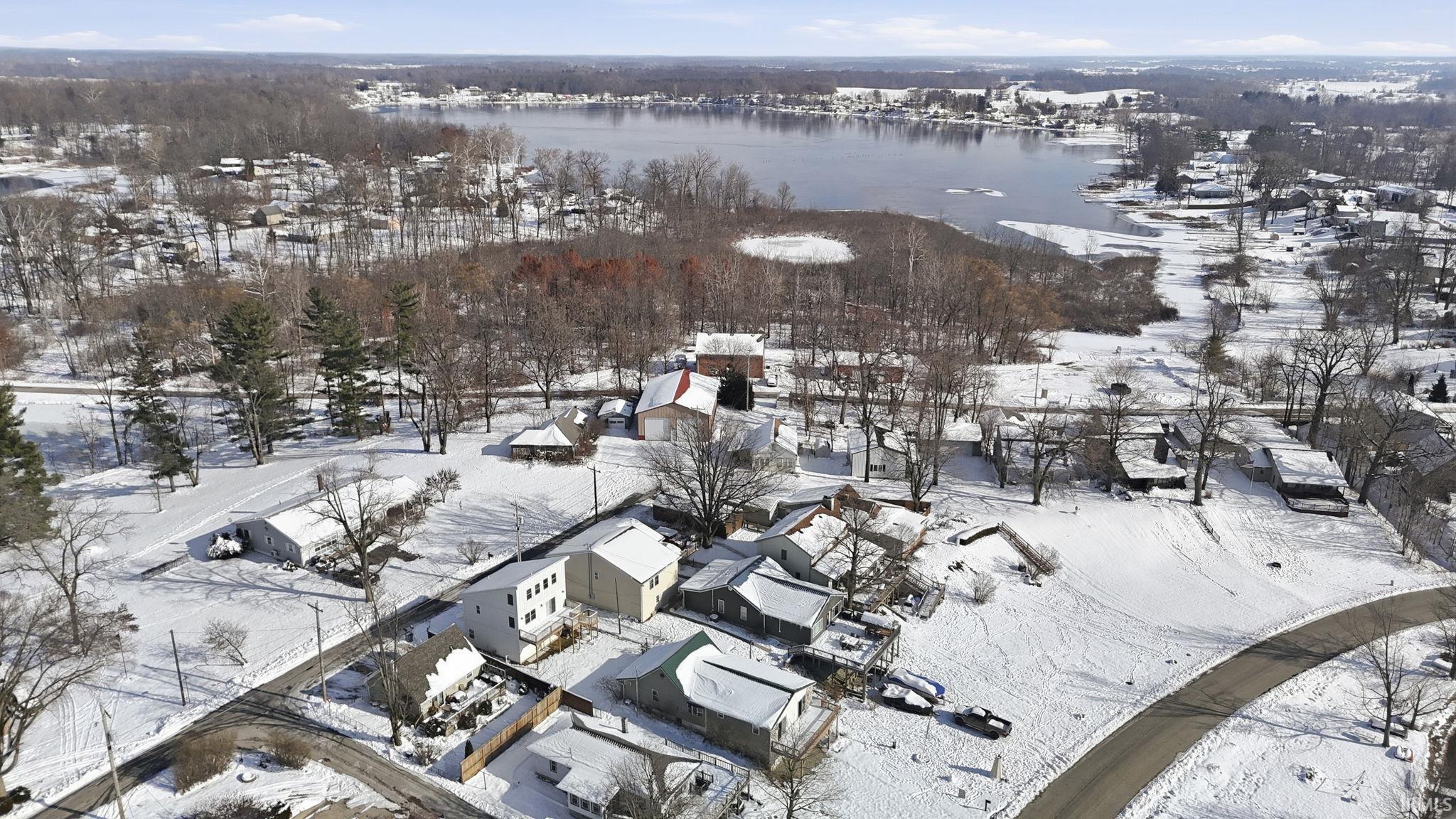 Snowy aerial view featuring a water view