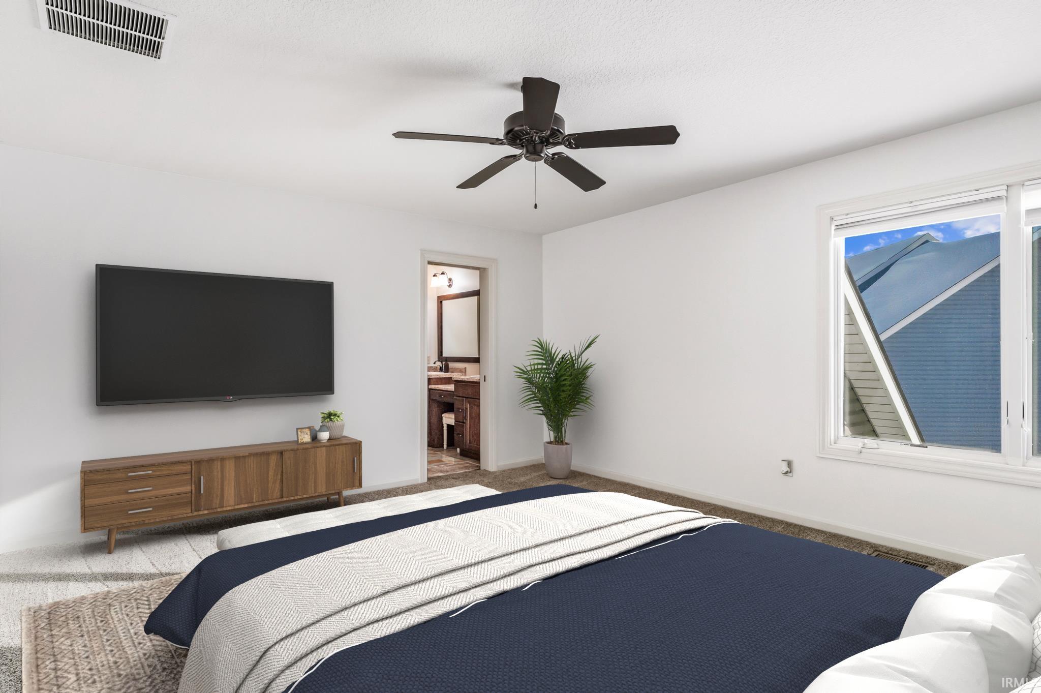 Bedroom featuring a ceiling fan, carpet floors, and ensuite bathroom