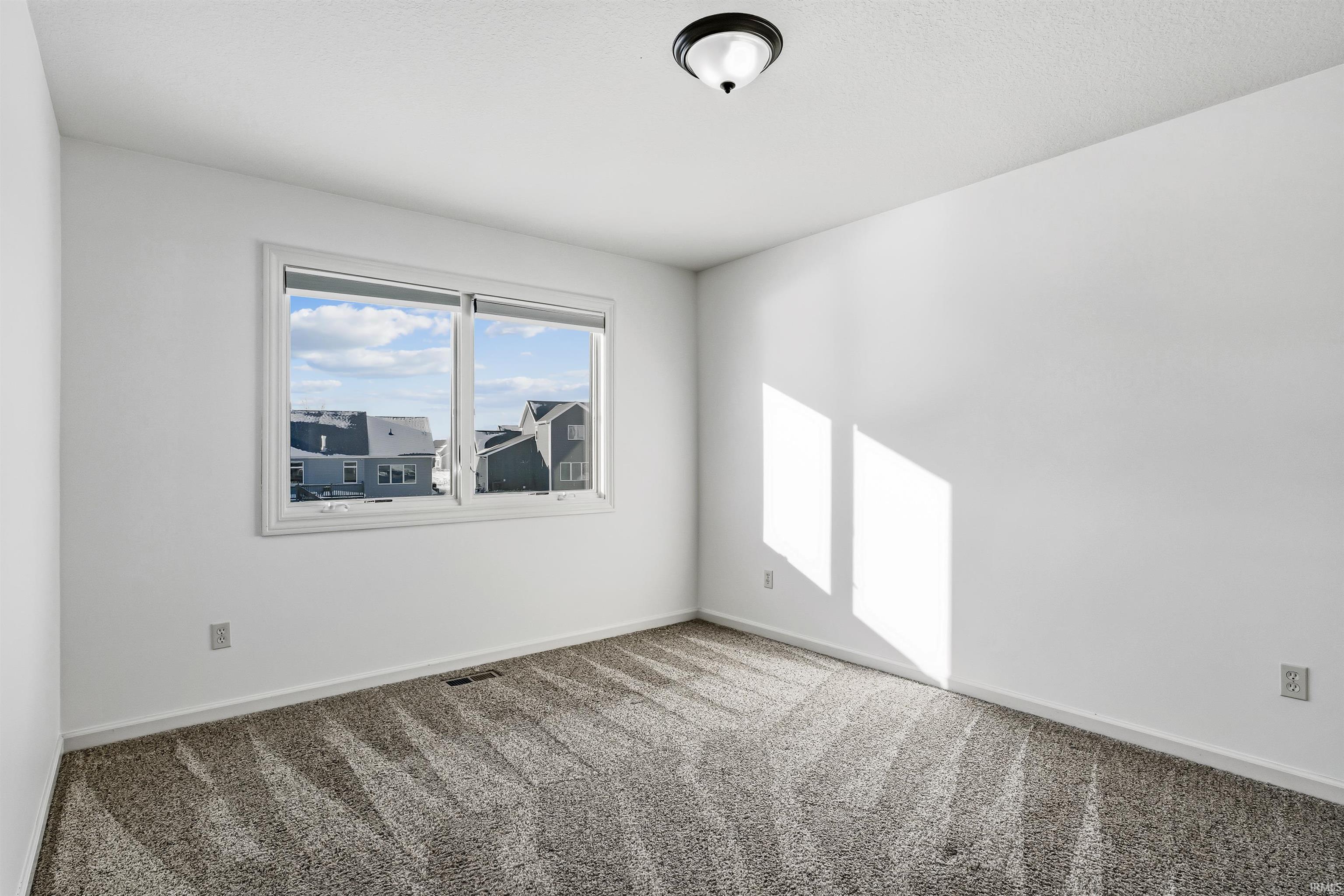 Carpeted empty room featuring baseboards