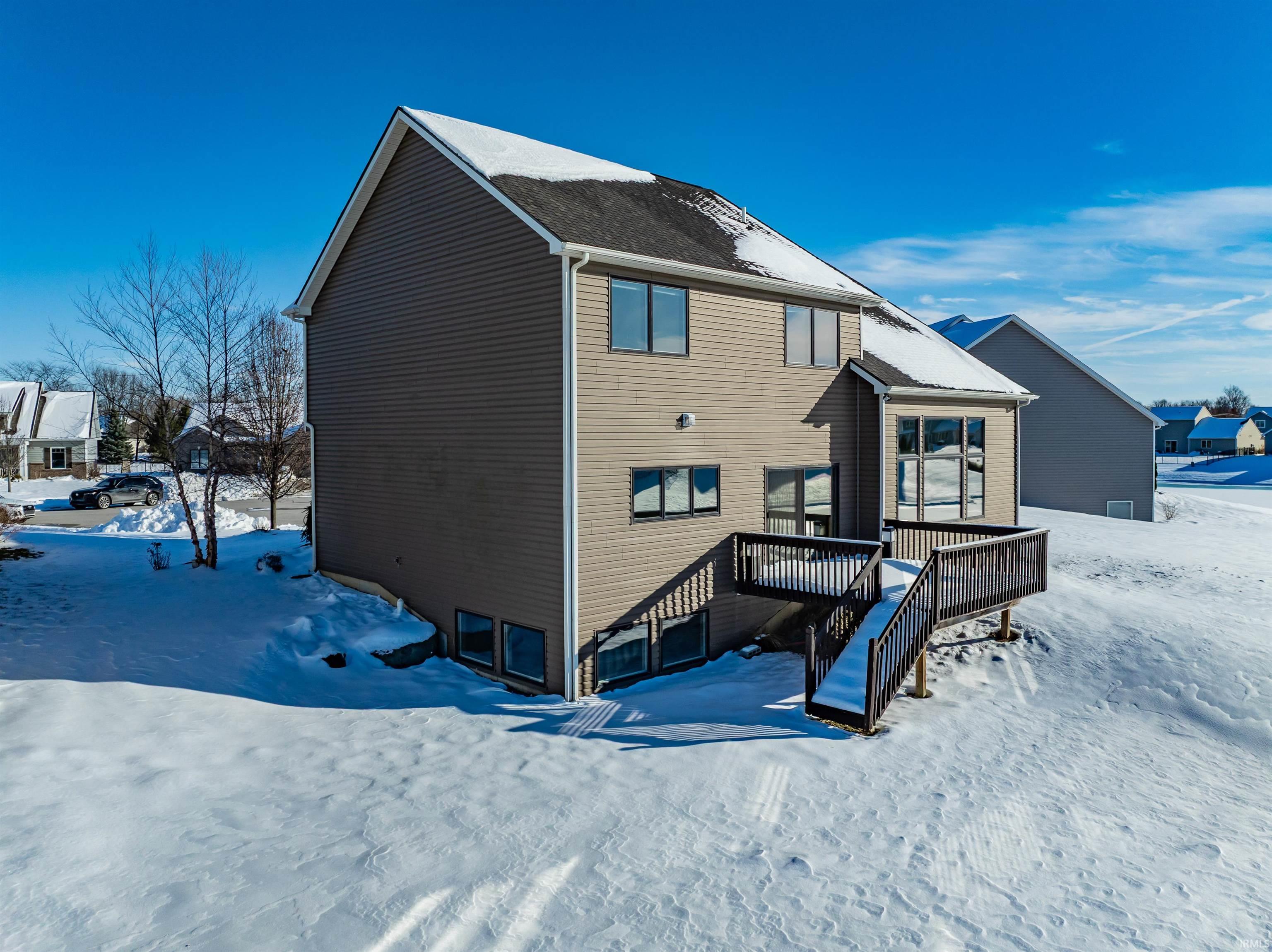 Snow covered property with a deck and stairway