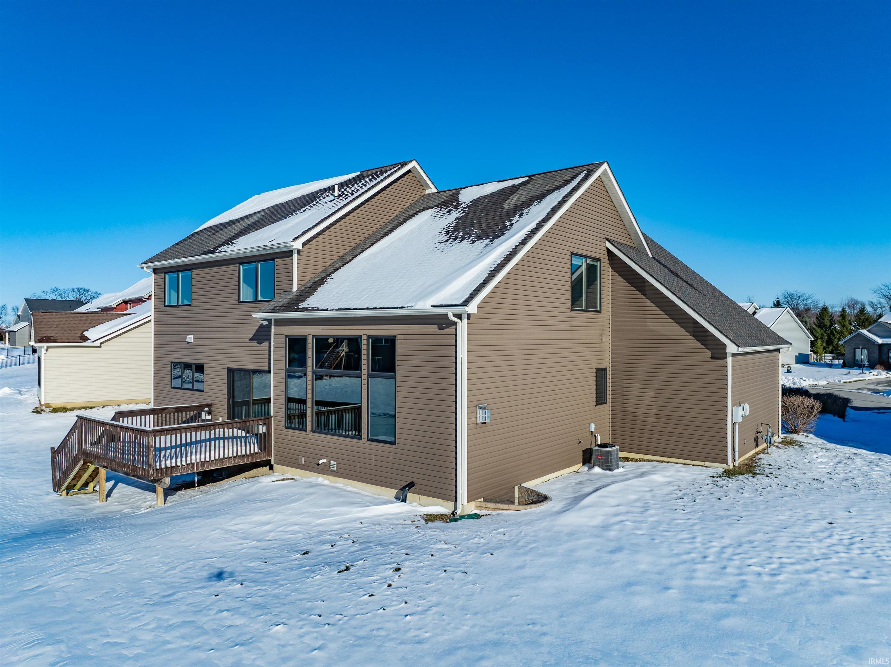Snow covered house featuring a wooden deck