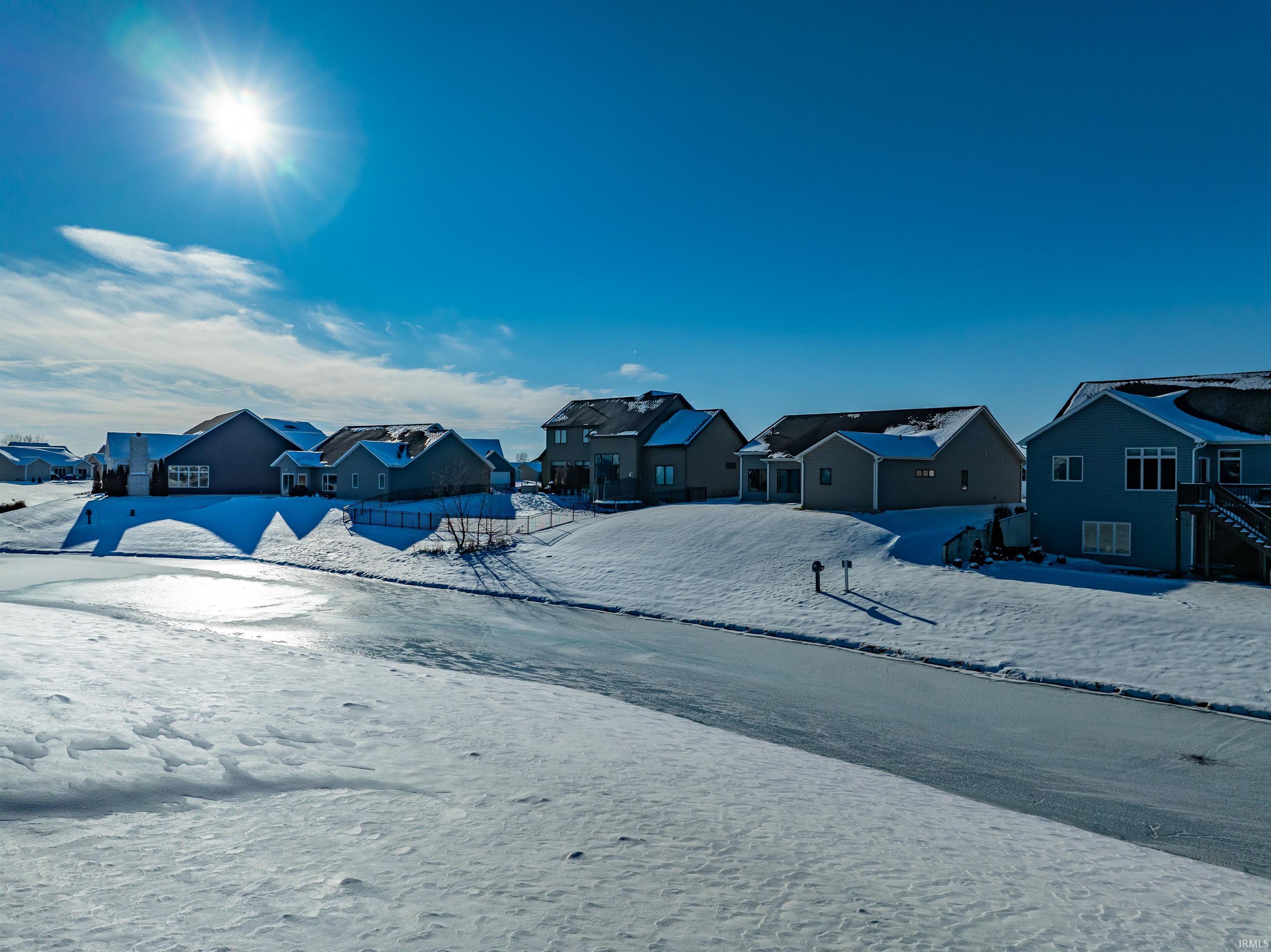 Yard covered in snow featuring a residential view