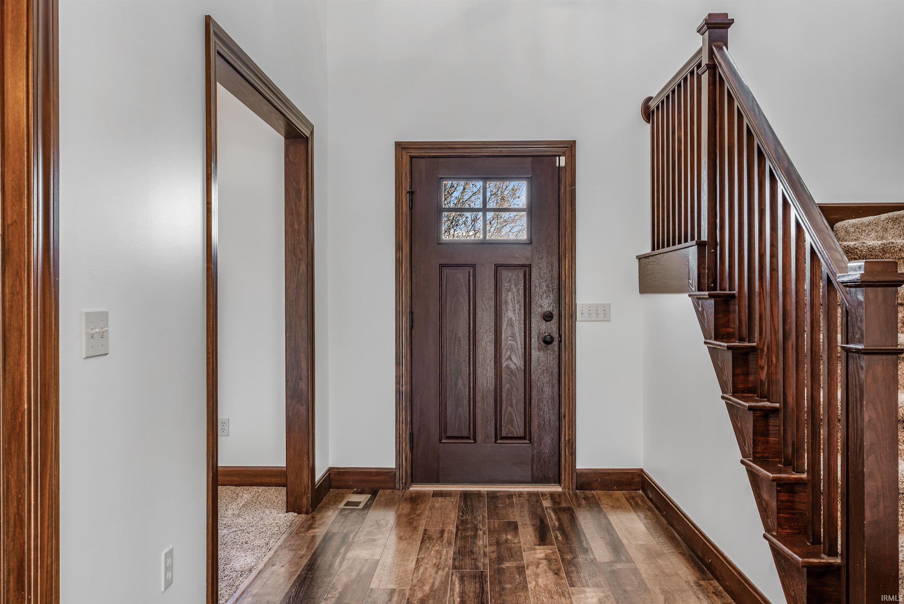 Entrance foyer with wood-type flooring and stairs