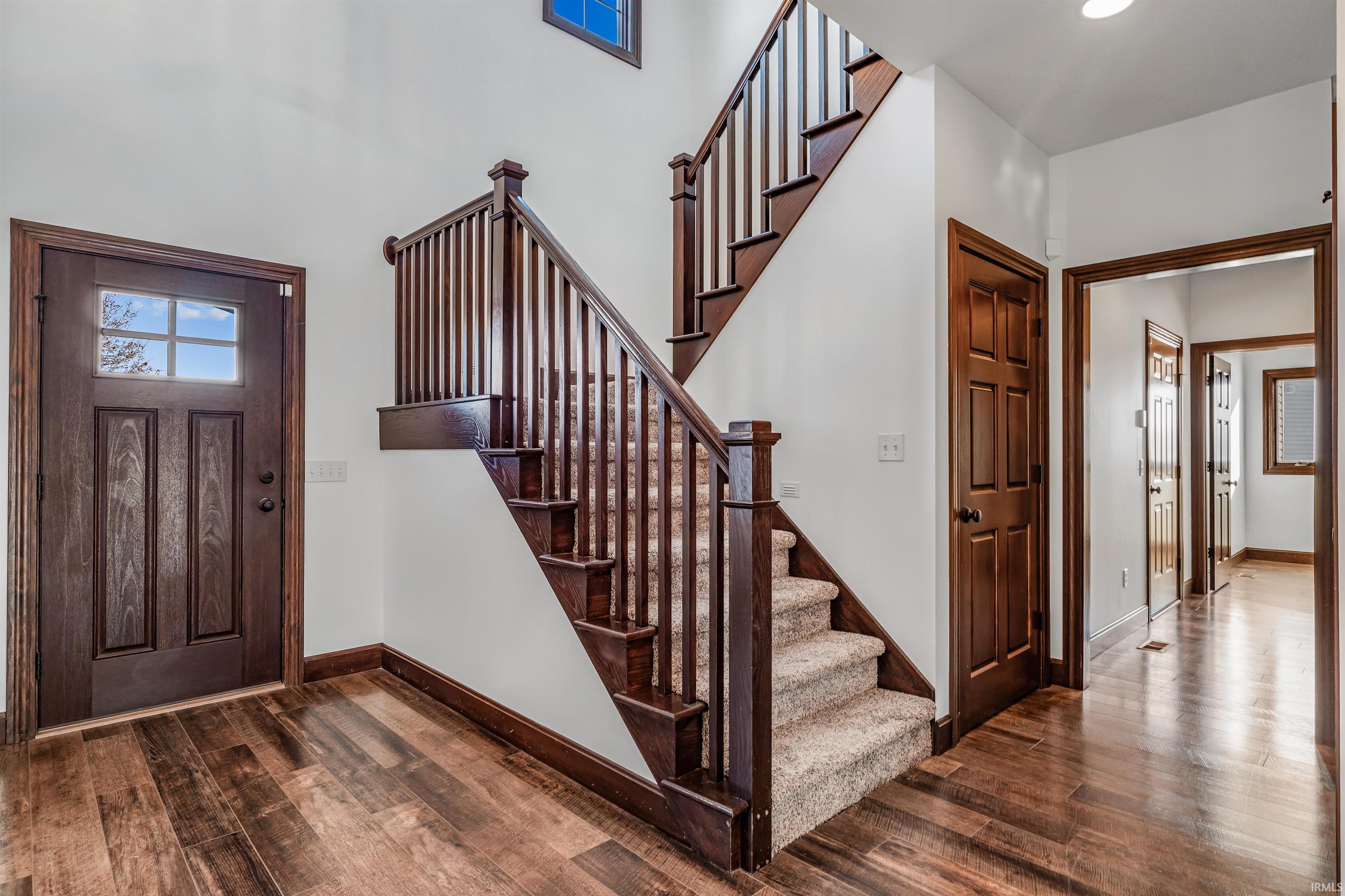 Entryway featuring dark wood finished floors, stairs, and recessed lighting