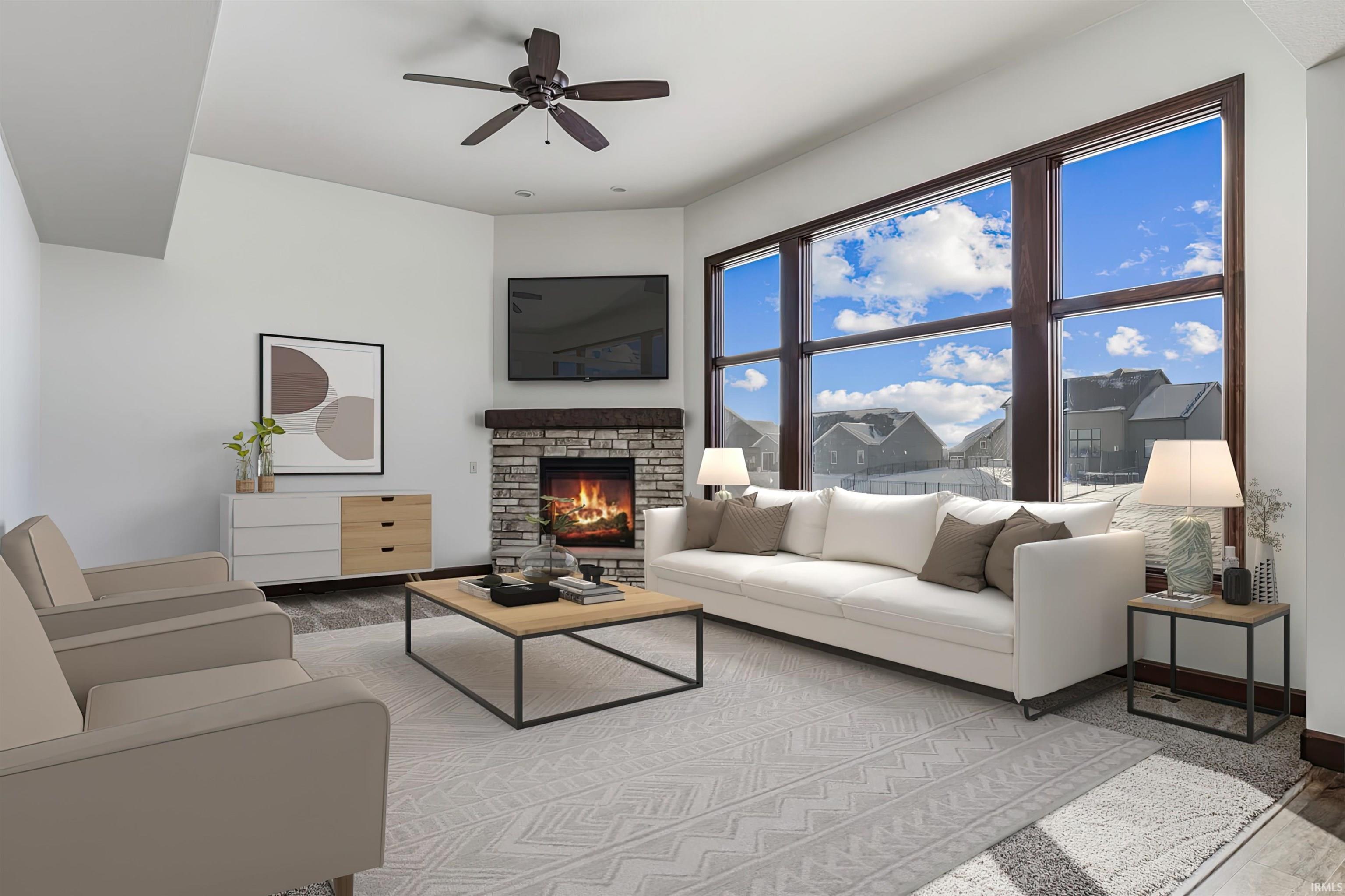 Living room with wood finished floors, a fireplace, and ceiling fan