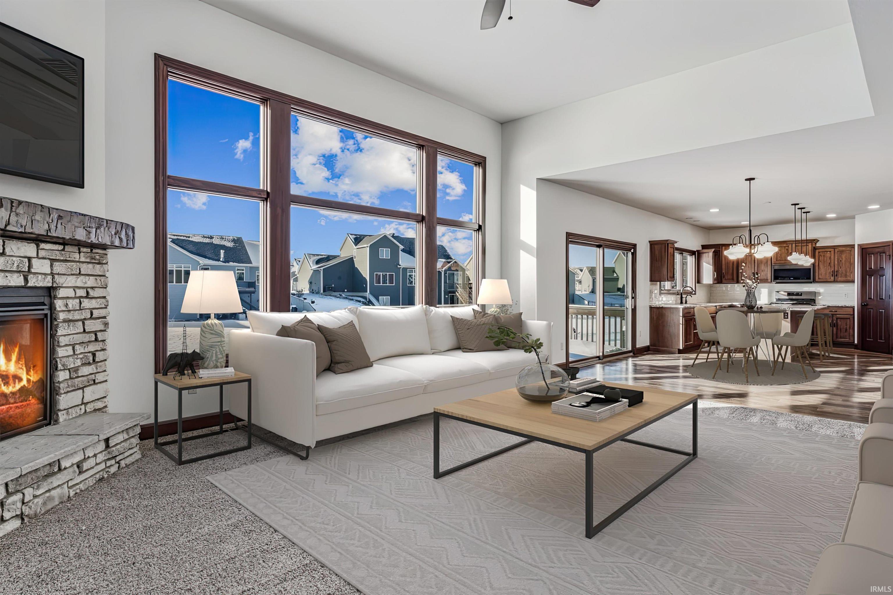 Living room with a fireplace, recessed lighting, and a ceiling fan