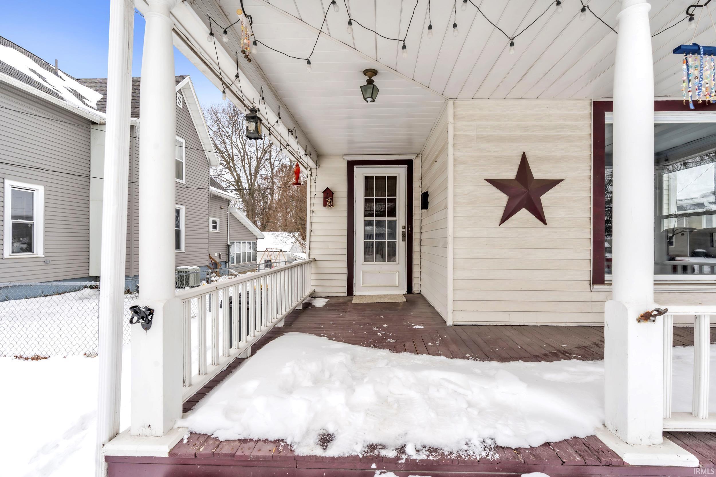 Snow covered property entrance featuring a wooden deck