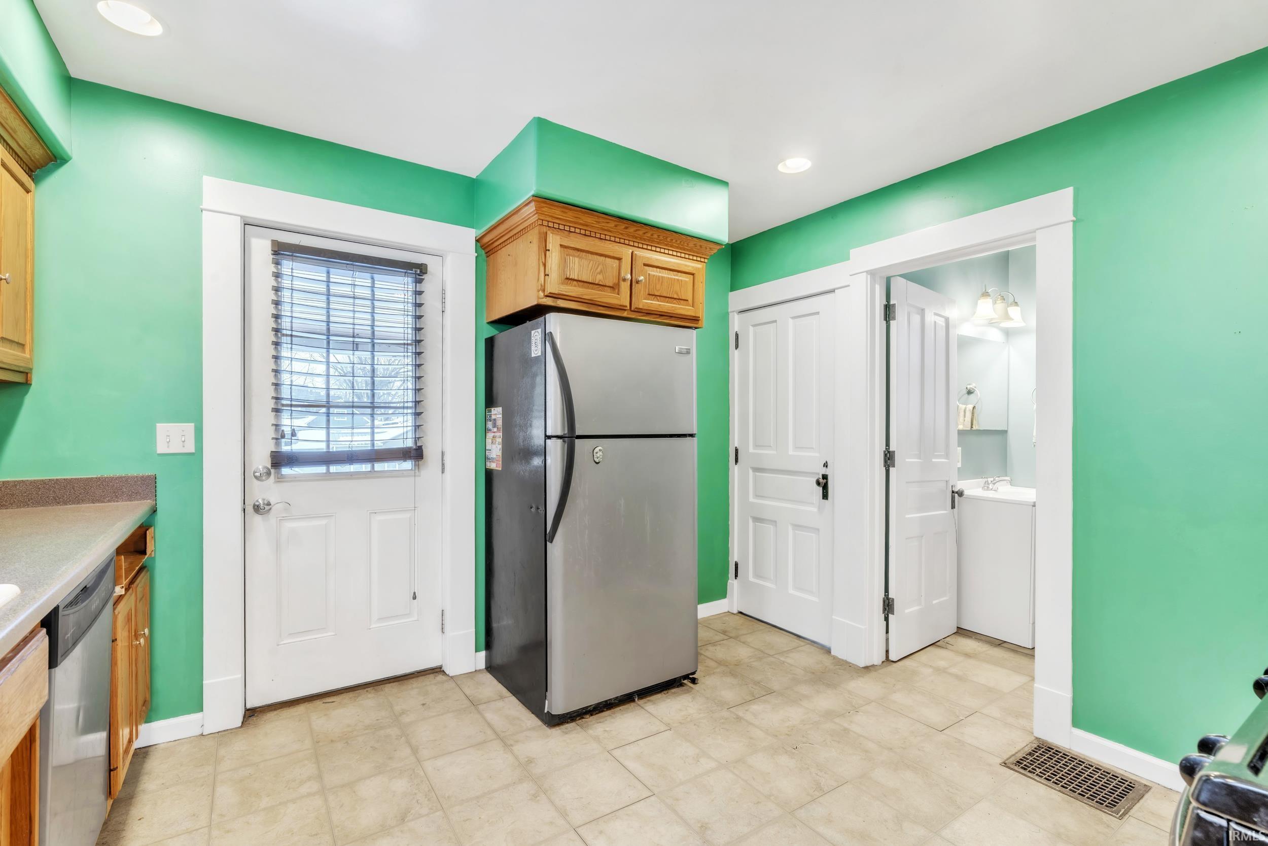 Kitchen with stainless steel appliances, light countertops, recessed lighting, brown cabinetry, and light flooring