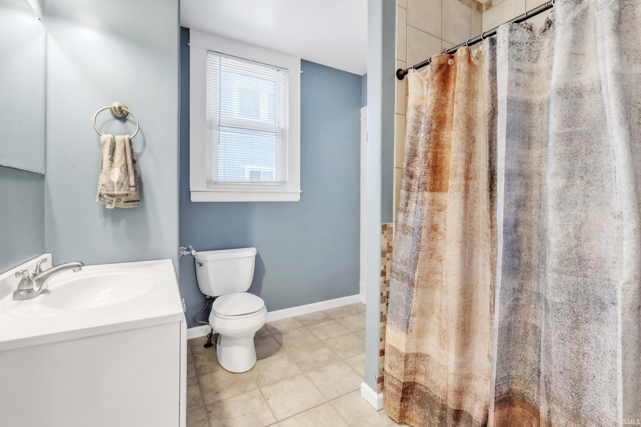 Full bath with a shower with curtain and vanity