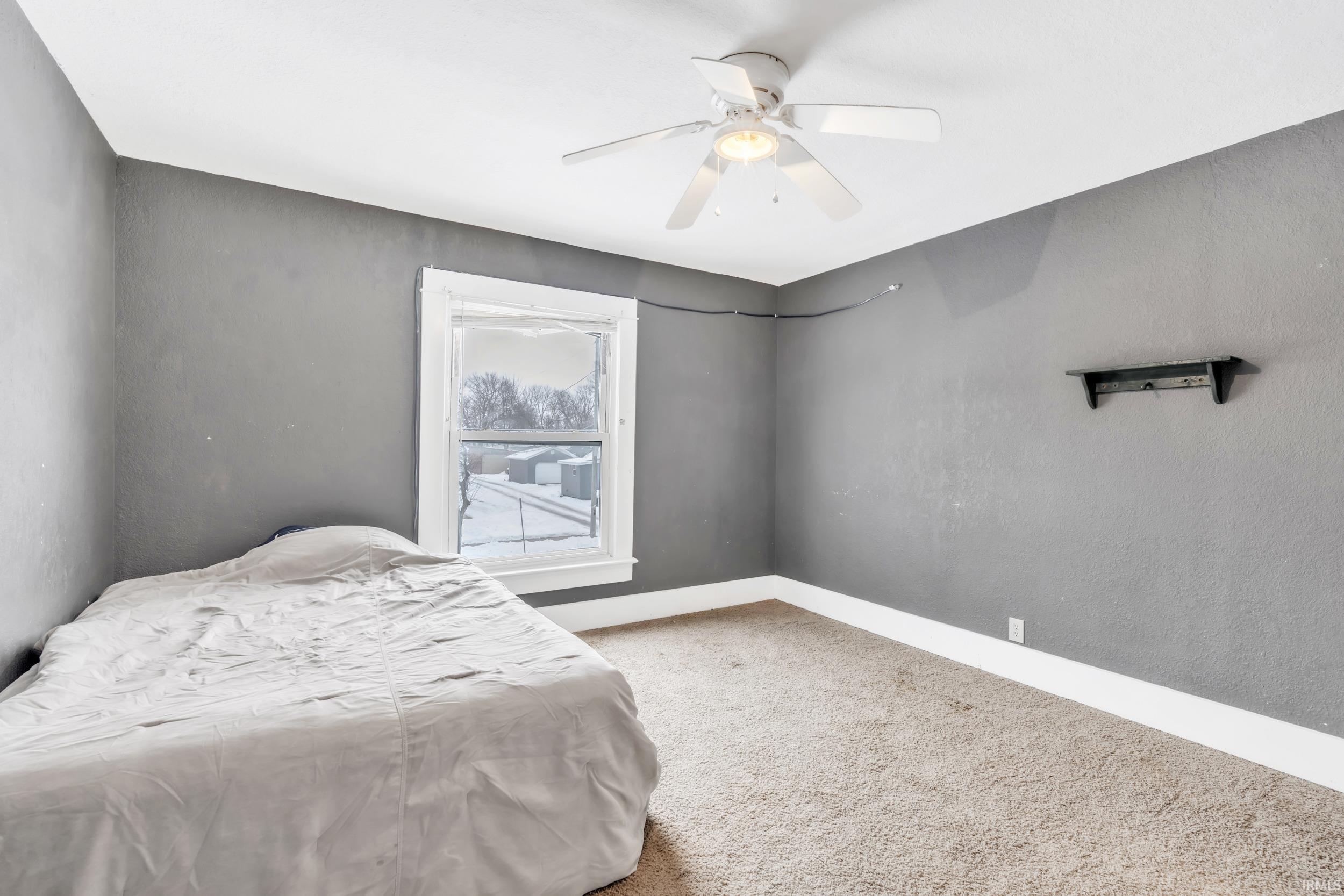 Carpeted bedroom featuring baseboards and ceiling fan