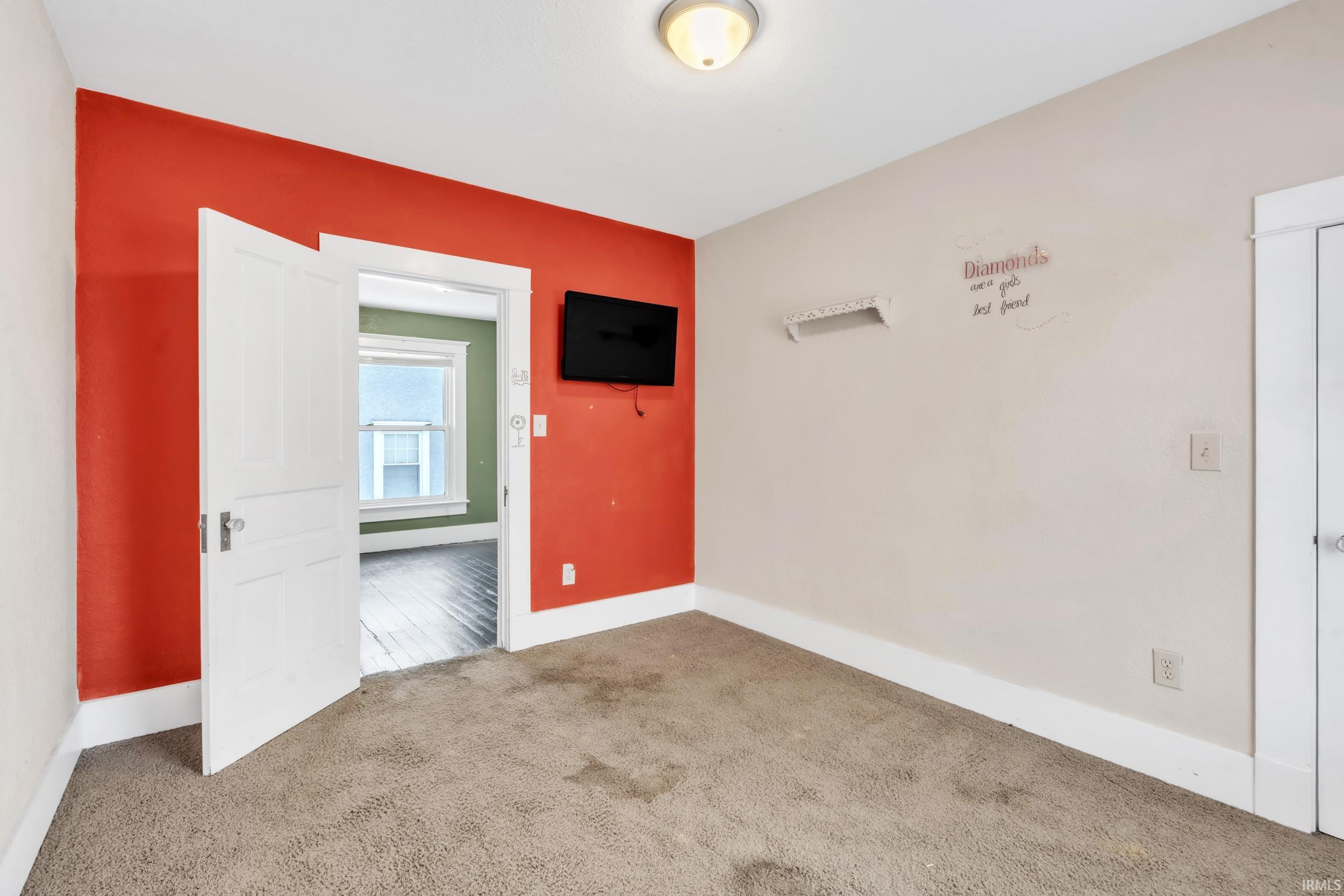 Carpeted empty room featuring baseboards