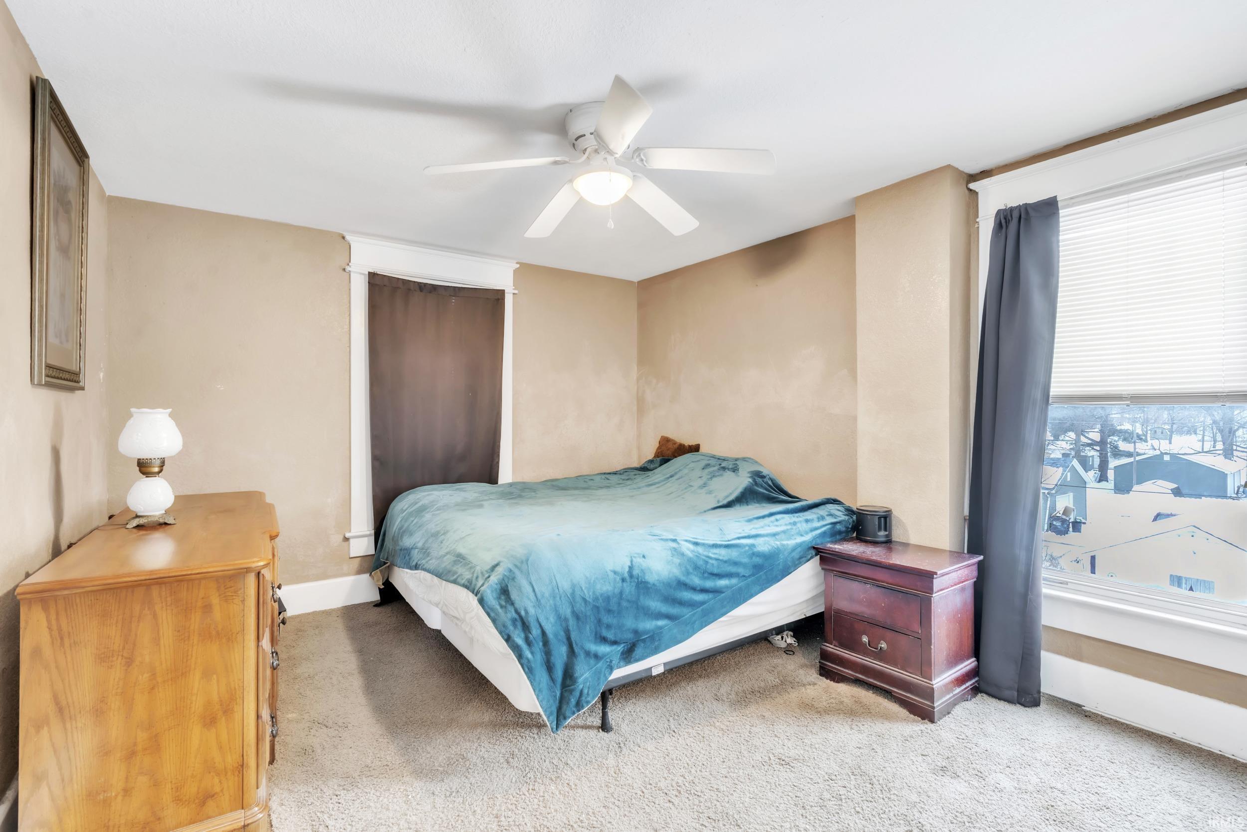 Bedroom featuring light colored carpet and a ceiling fan