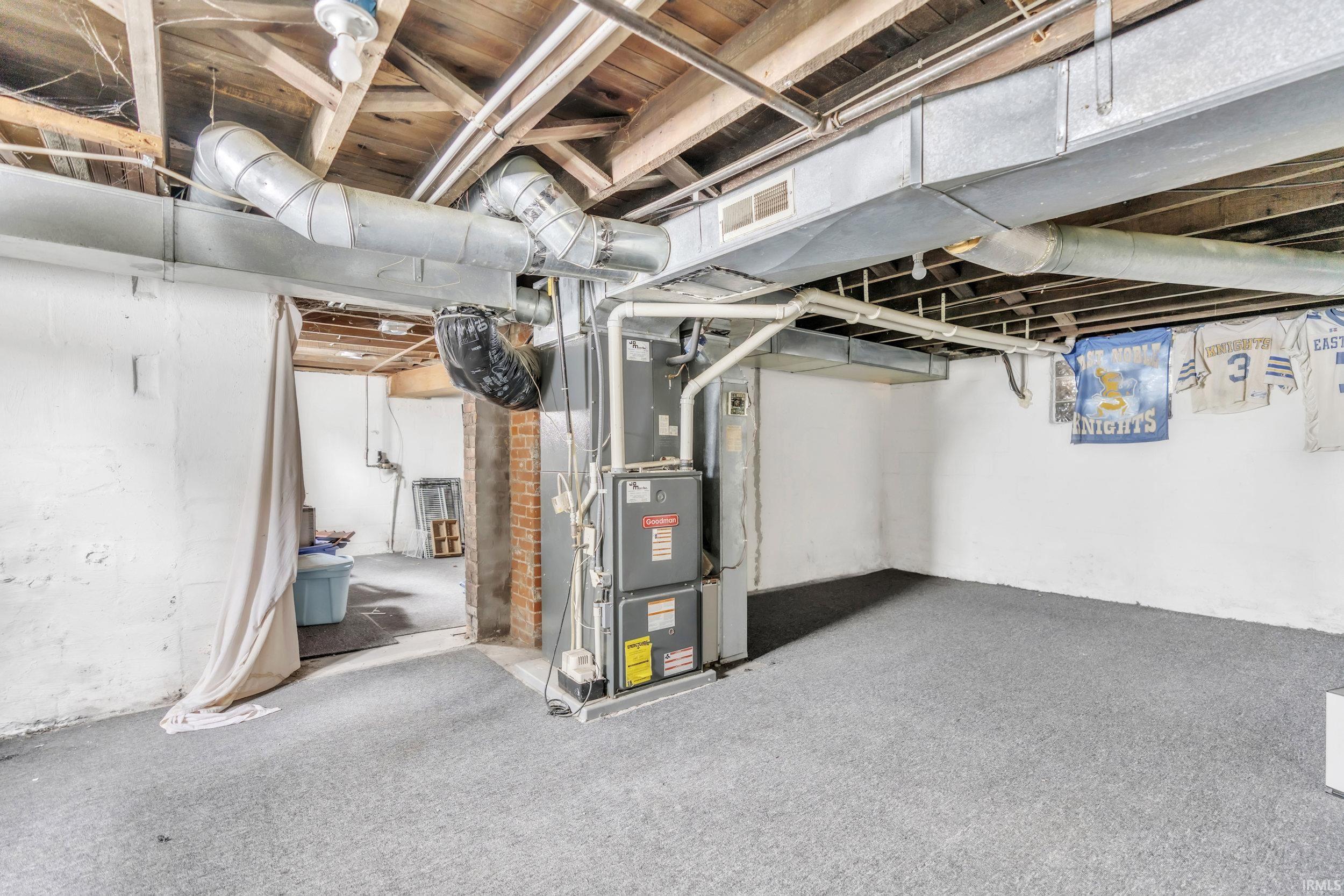 Unfinished basement with heating unit and carpet