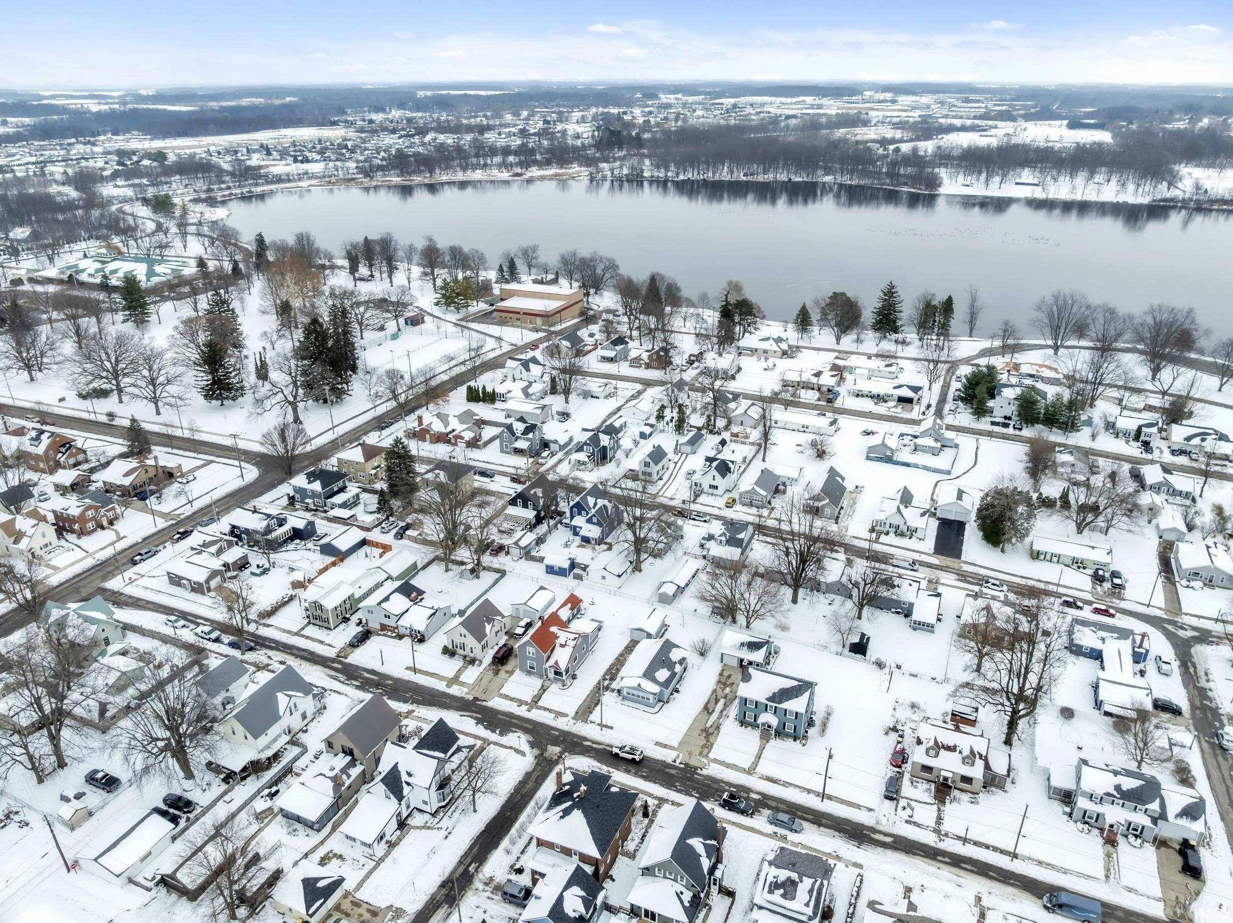 Snowy aerial view with a water view