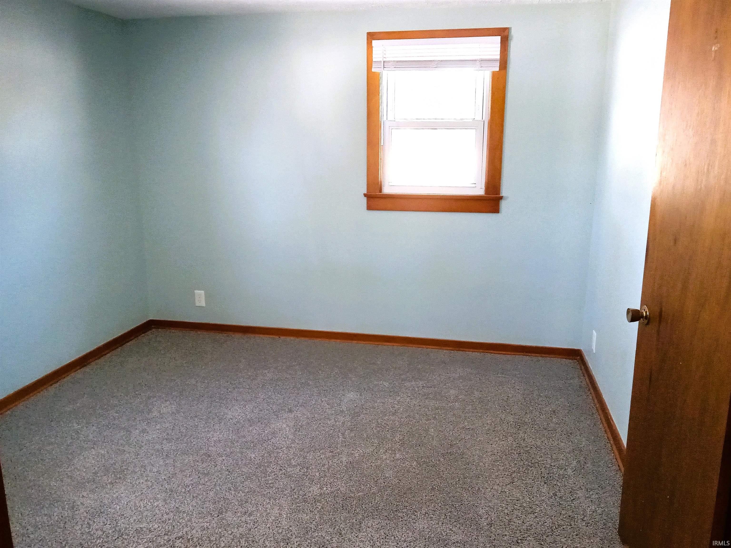Empty room featuring carpet flooring and baseboards