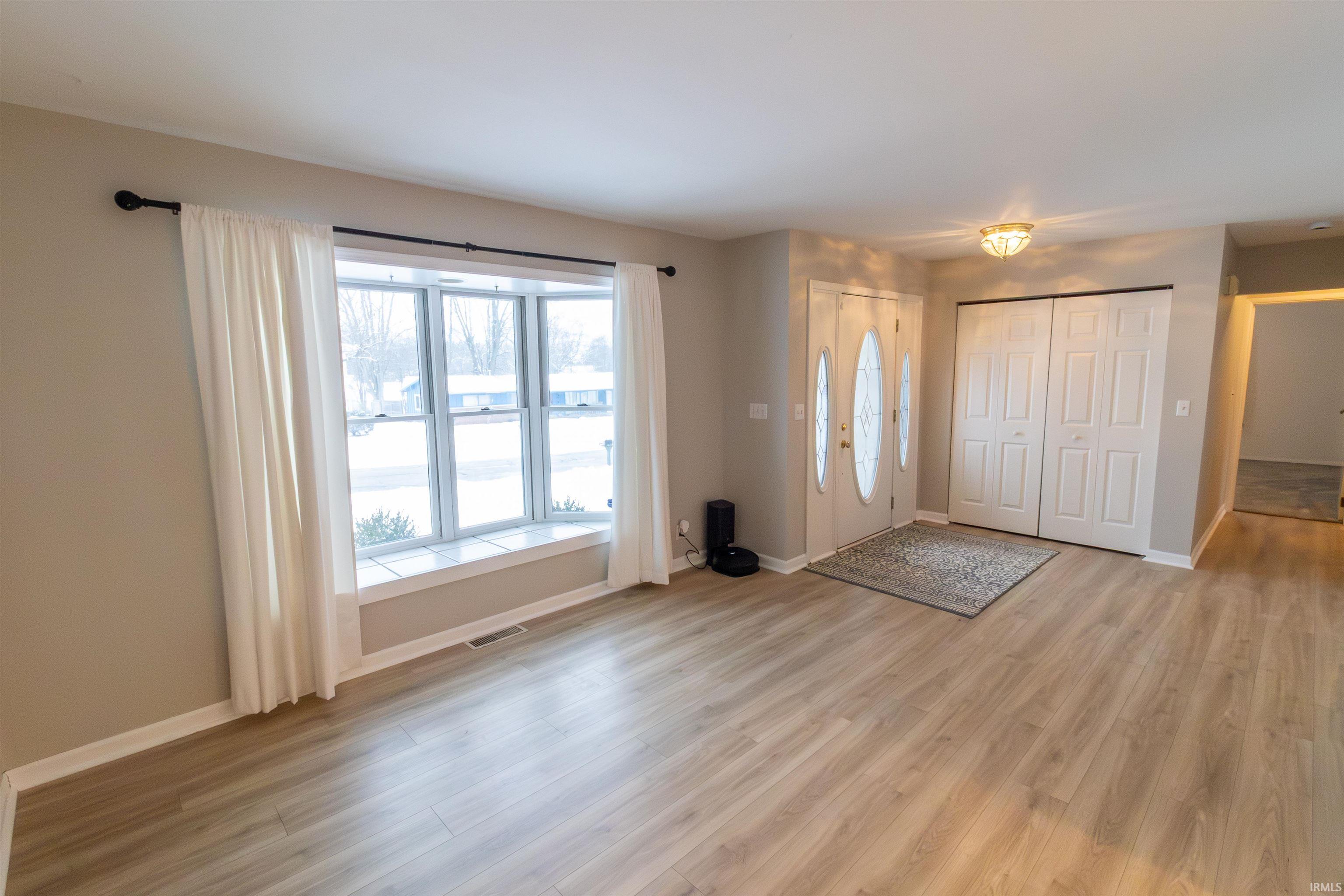 Foyer with baseboards and light wood-style floors