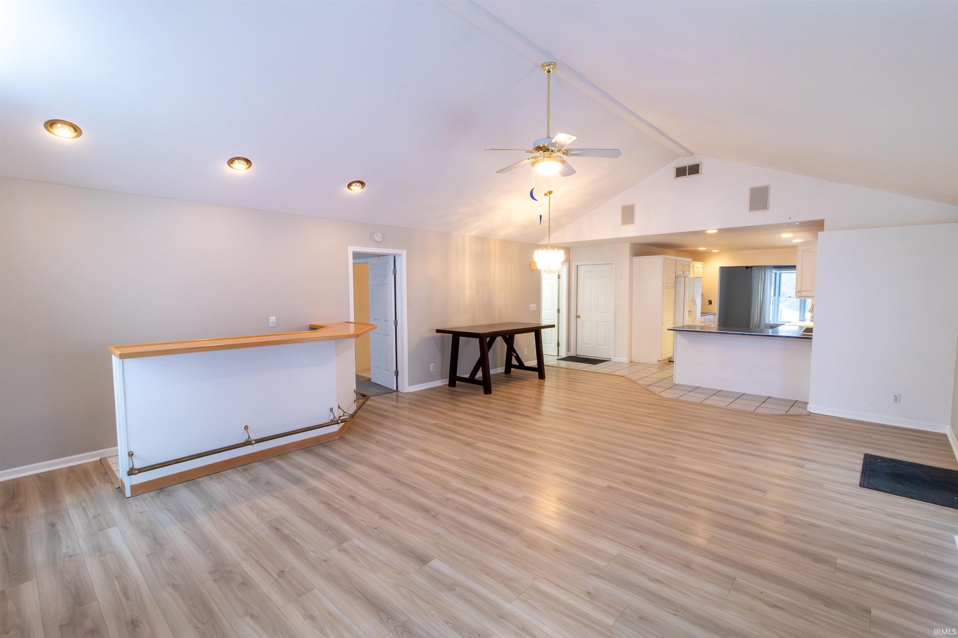 Unfurnished living room with light wood finished floors, a ceiling fan, beamed ceiling, high vaulted ceiling, and recessed lighting