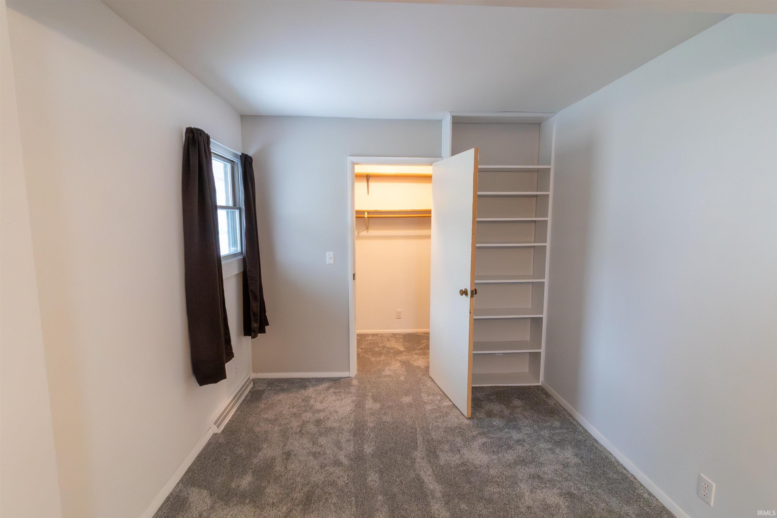 Unfurnished bedroom featuring a spacious closet and carpet