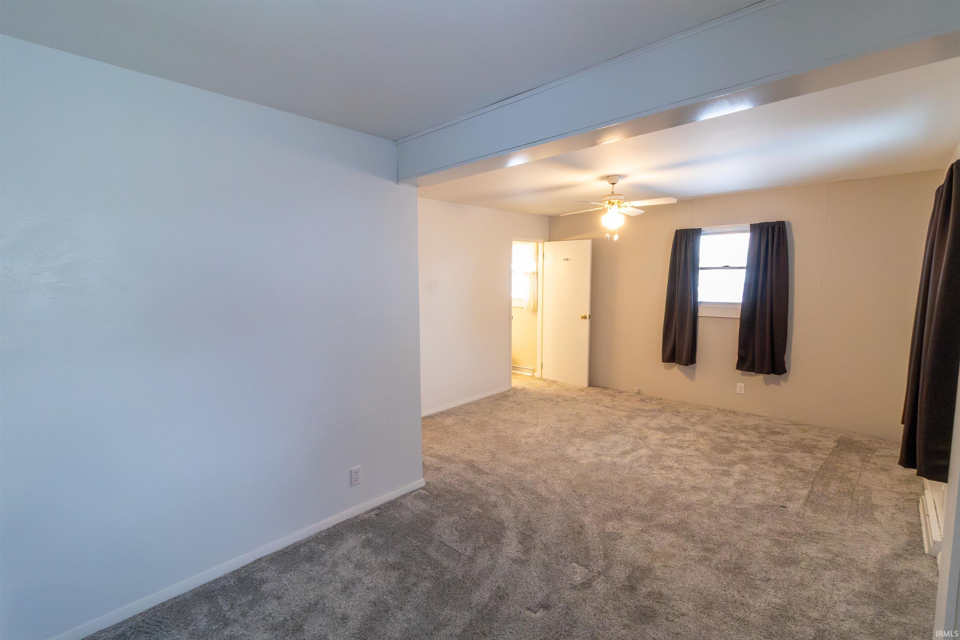 Unfurnished room featuring carpet floors and ceiling fan