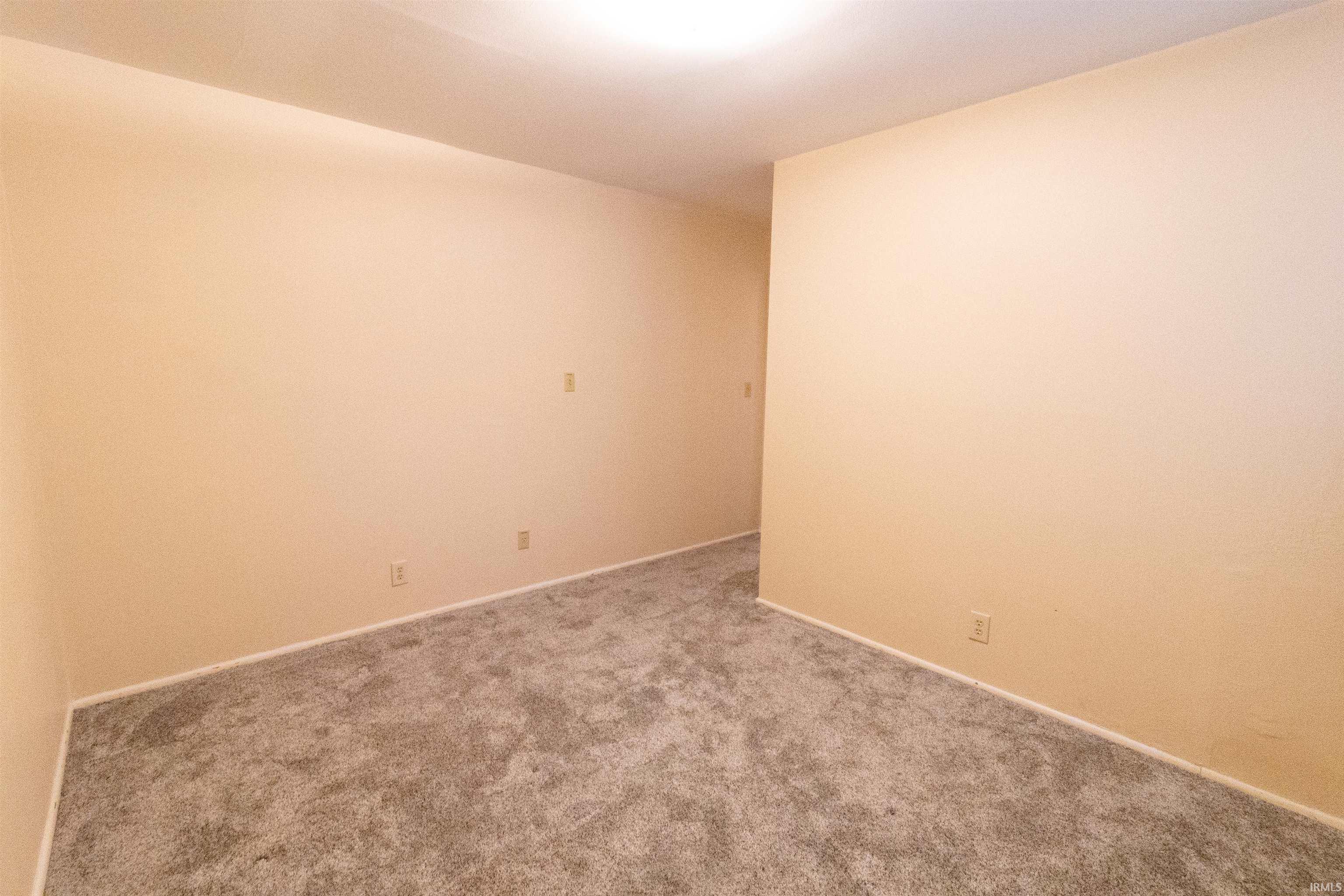 Empty room with carpet and baseboards