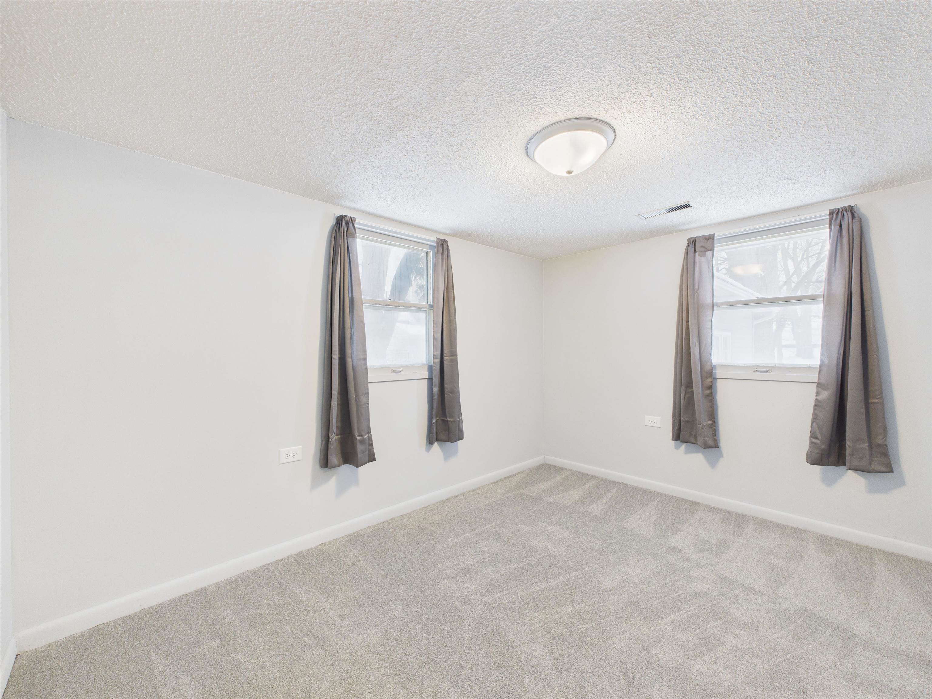 Unfurnished room with a textured ceiling and carpet floors