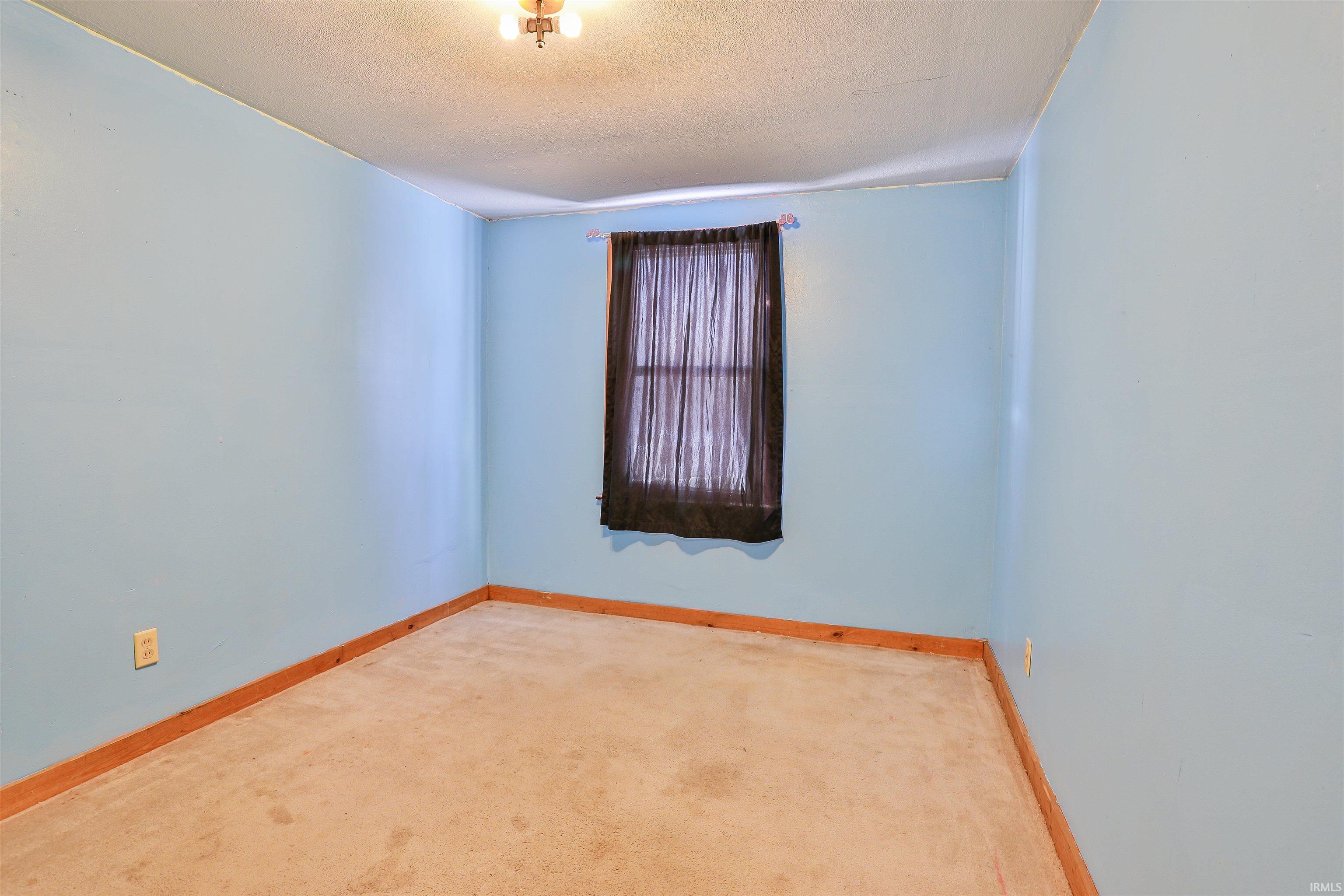 Empty room featuring carpet and a textured ceiling
