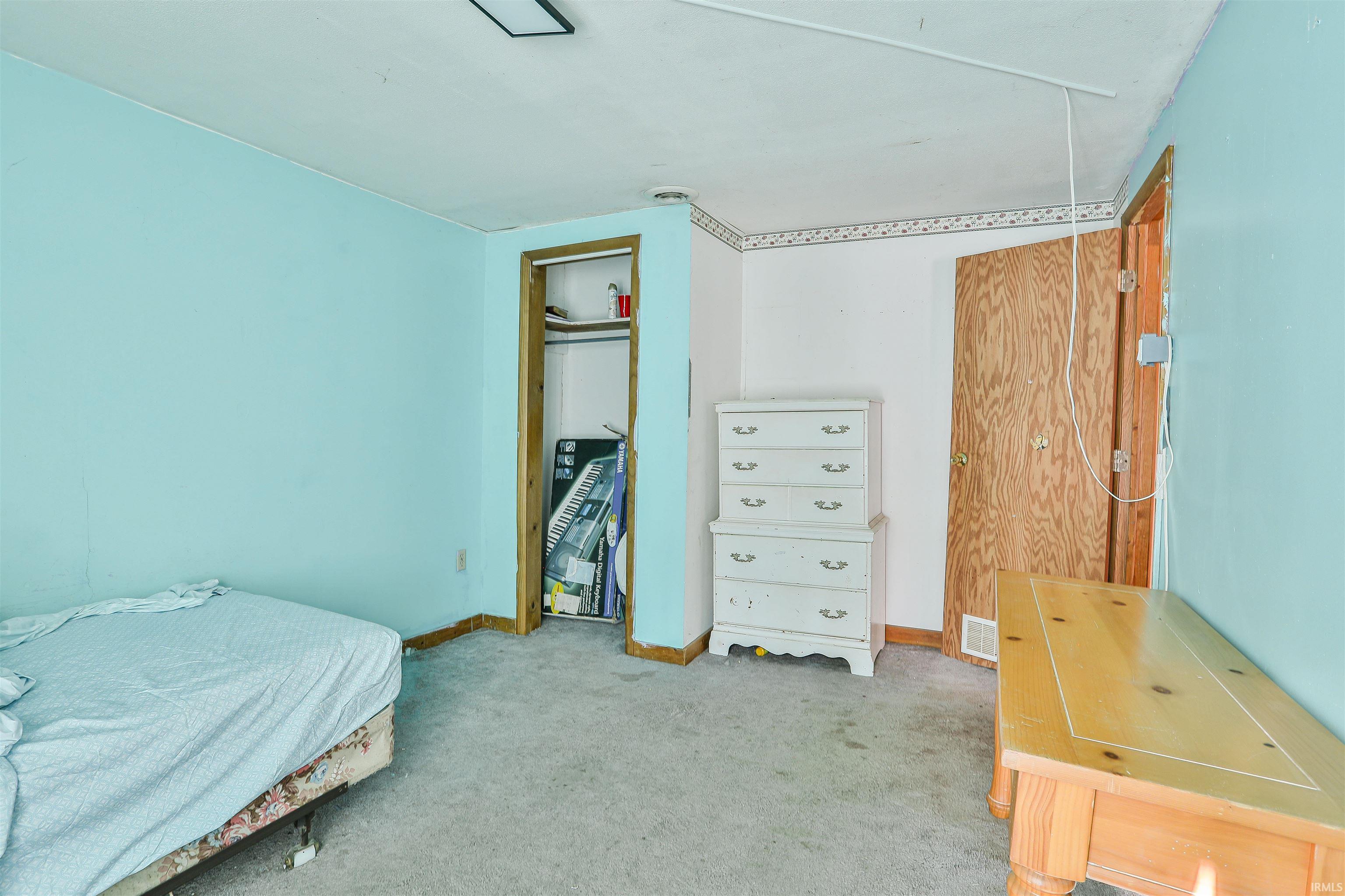 Carpeted bedroom with attic access and a closet