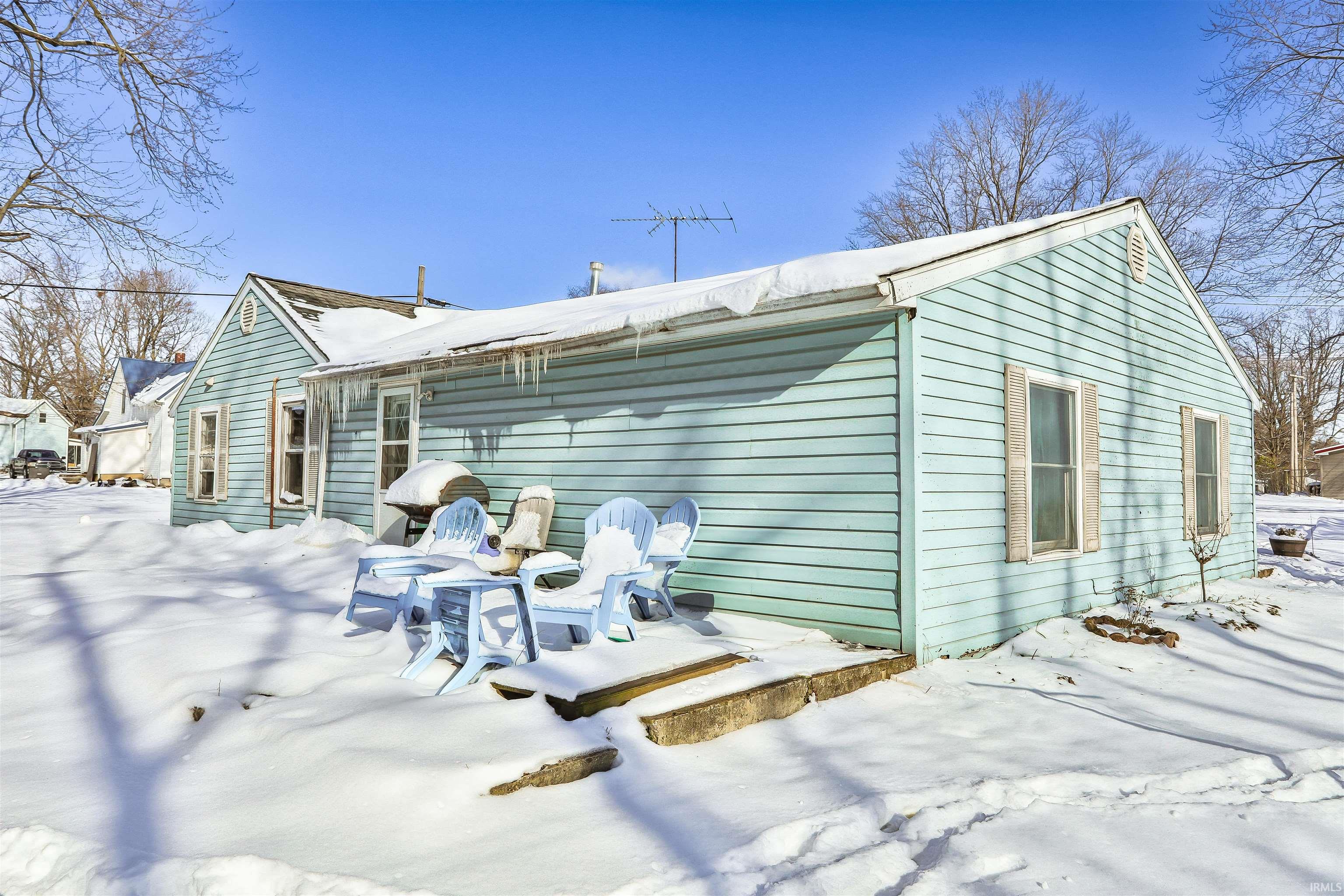 View of snow covered back of property