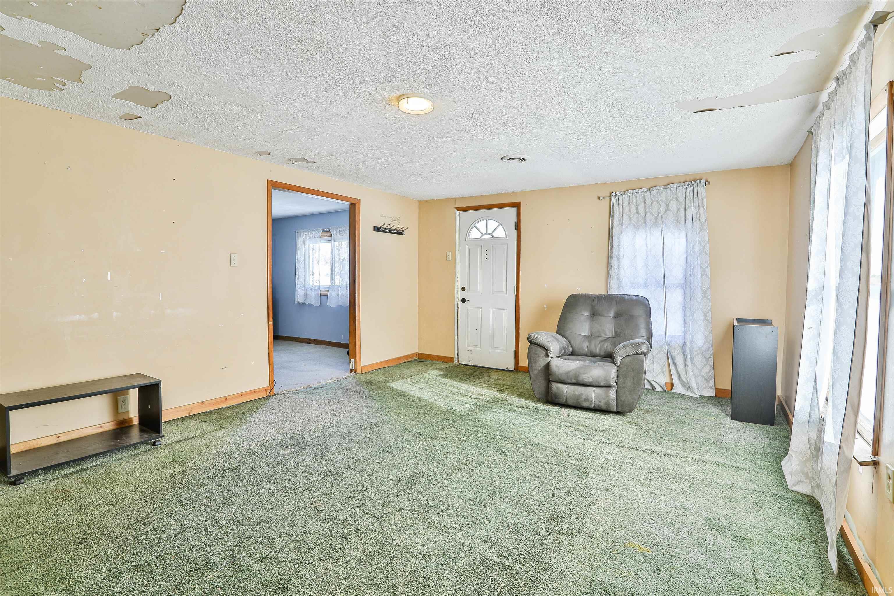Unfurnished room featuring a textured ceiling and carpet floors