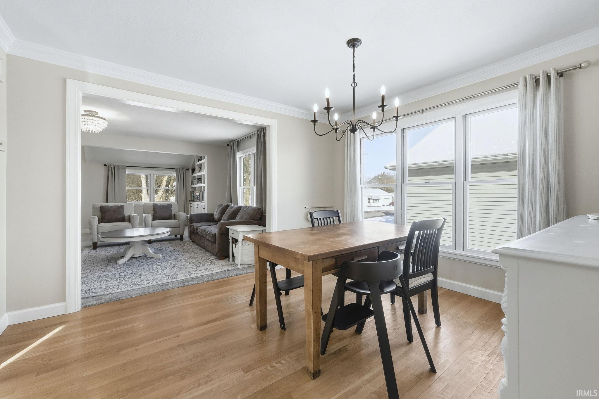 Dining room featuring a chandelier, light wood-style flooring, and ornamental molding