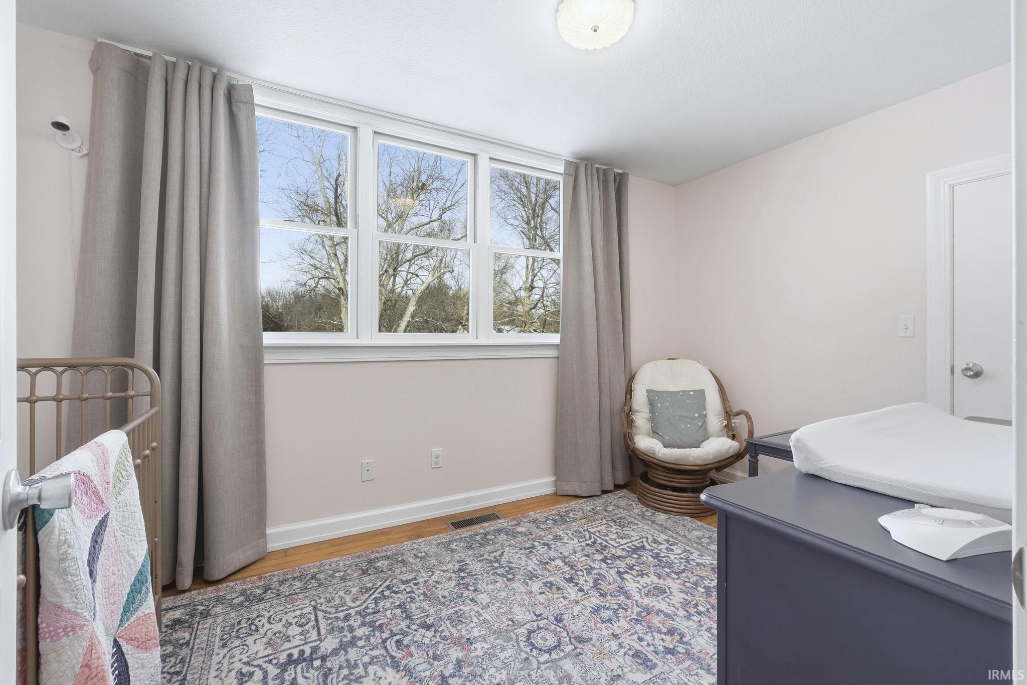 Bedroom with light wood finished floors and baseboards