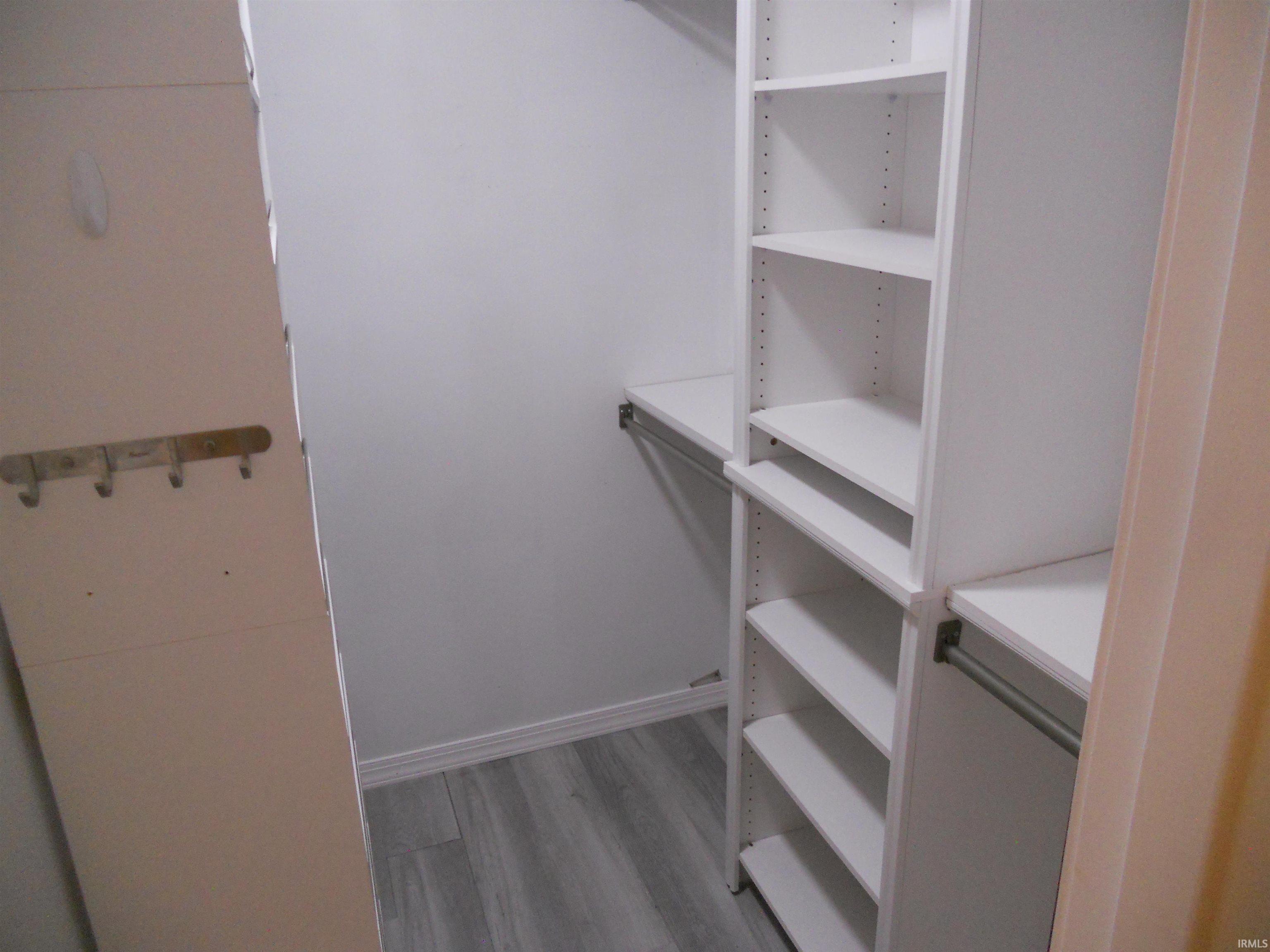 Walk in closet with light wood-style floors