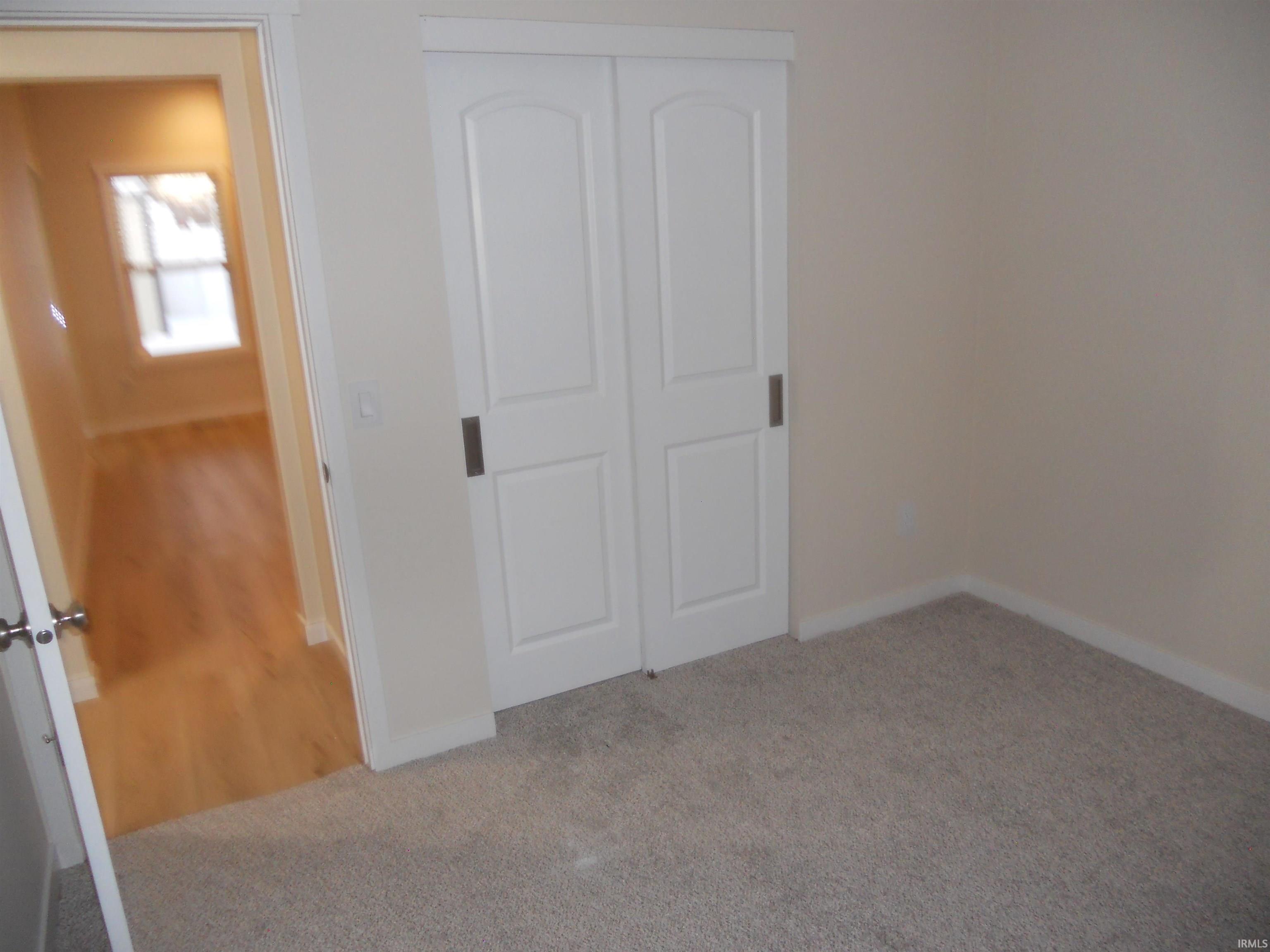 Unfurnished bedroom with a closet and light colored carpet