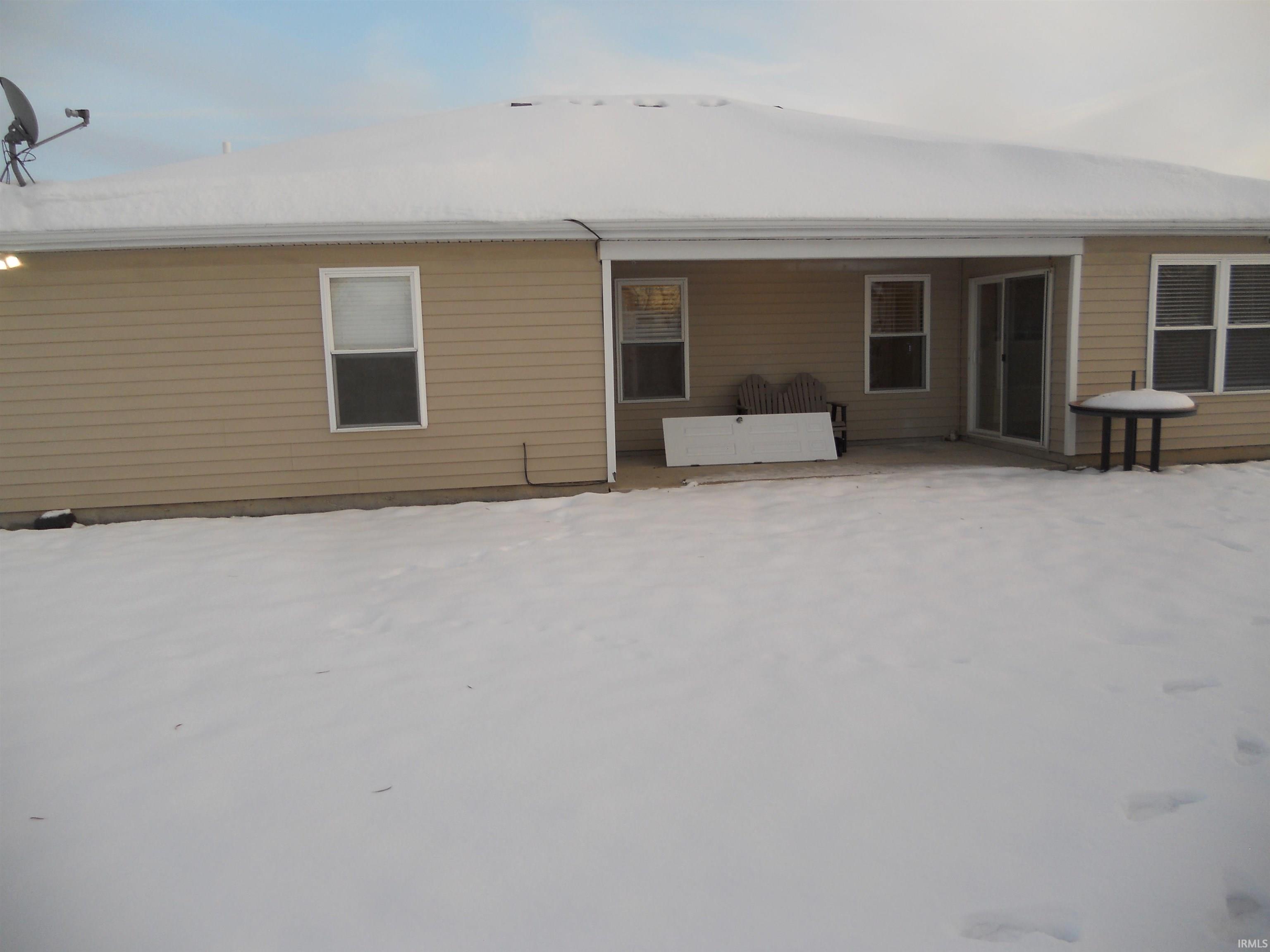 Snow covered property featuring a patio area