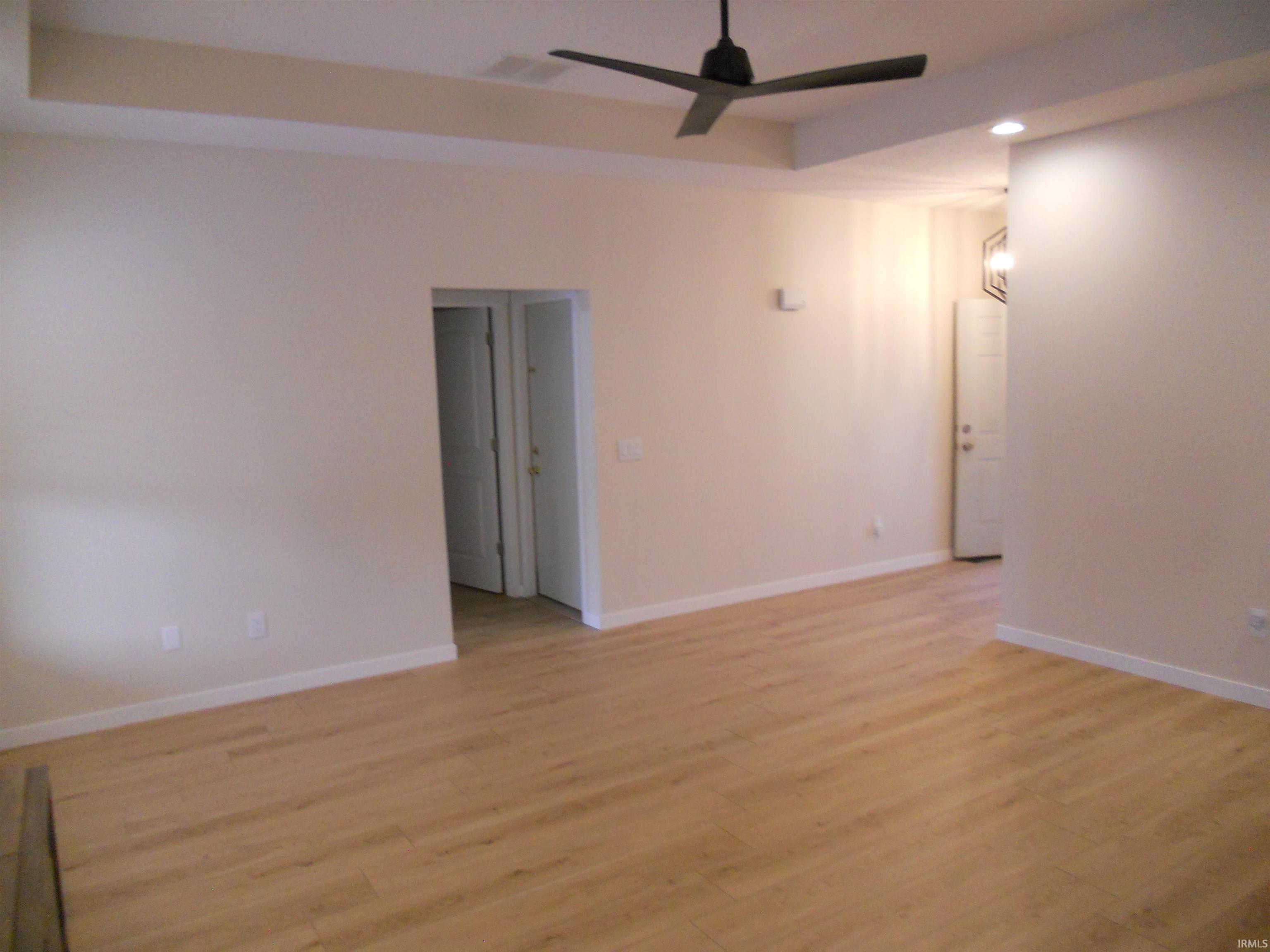 Unfurnished room with recessed lighting, a raised ceiling, light wood-style floors, and a ceiling fan