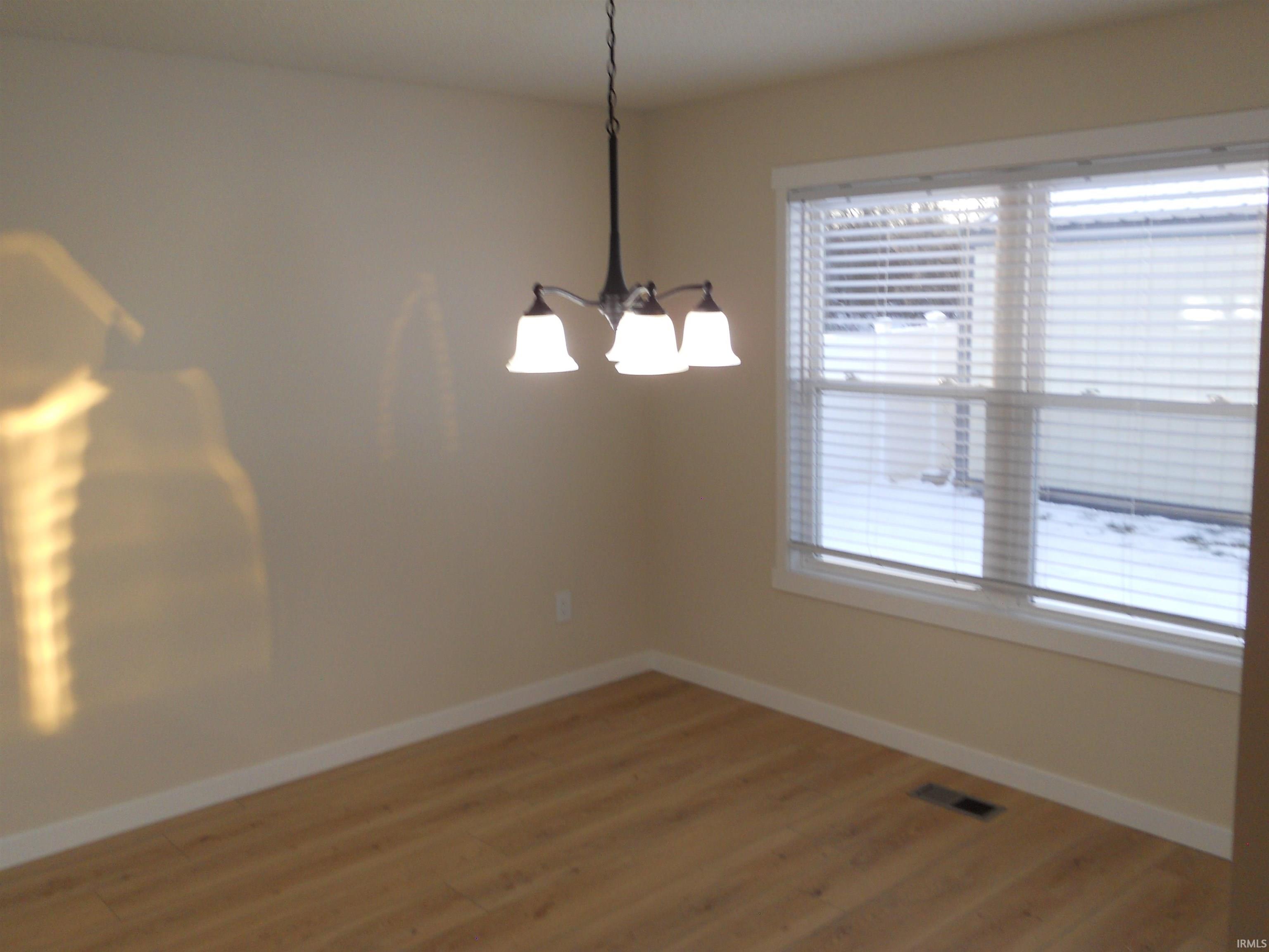 Unfurnished dining area with light wood-style floors and a chandelier