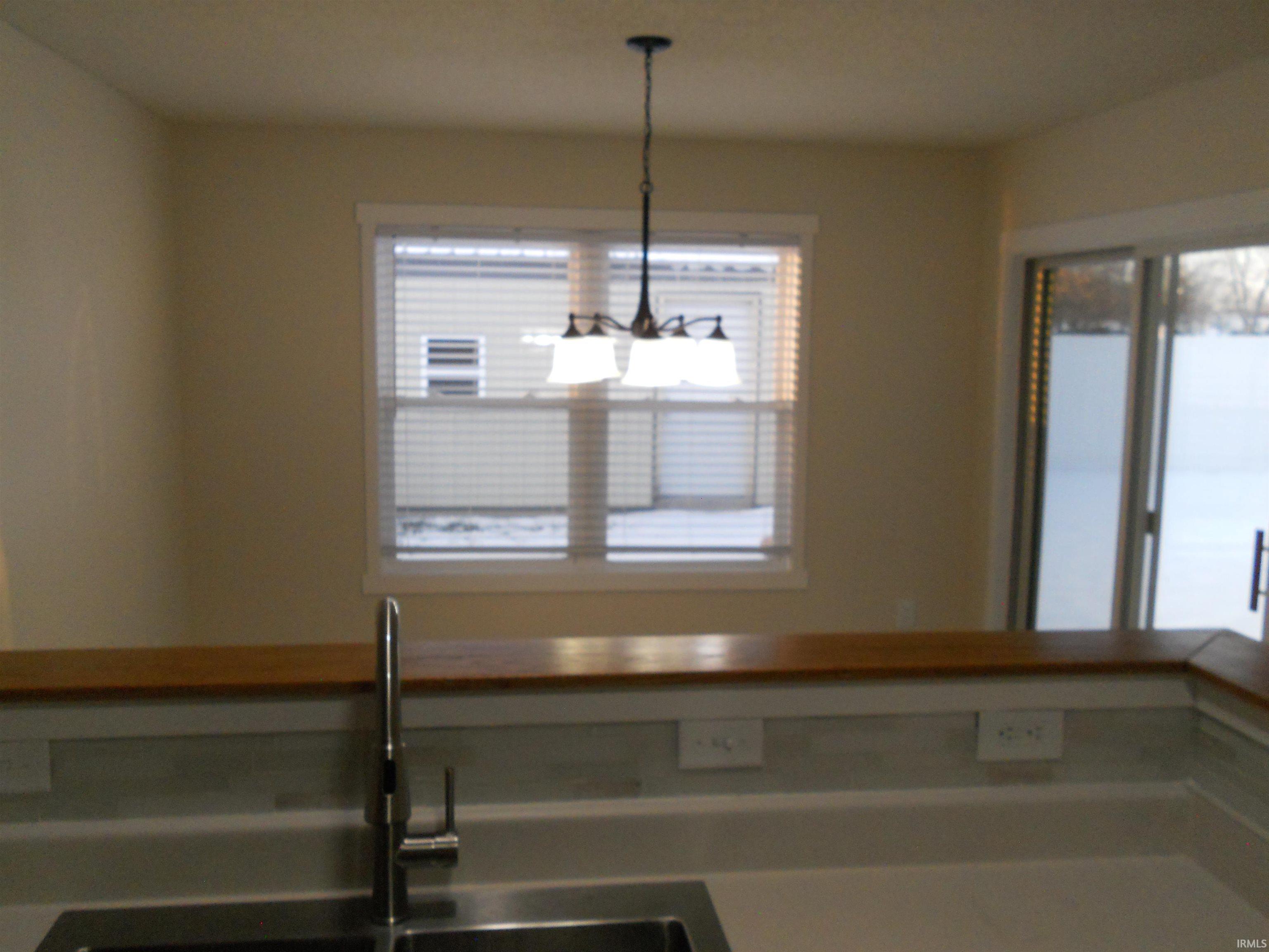 Kitchen with butcher block counters and decorative light fixtures