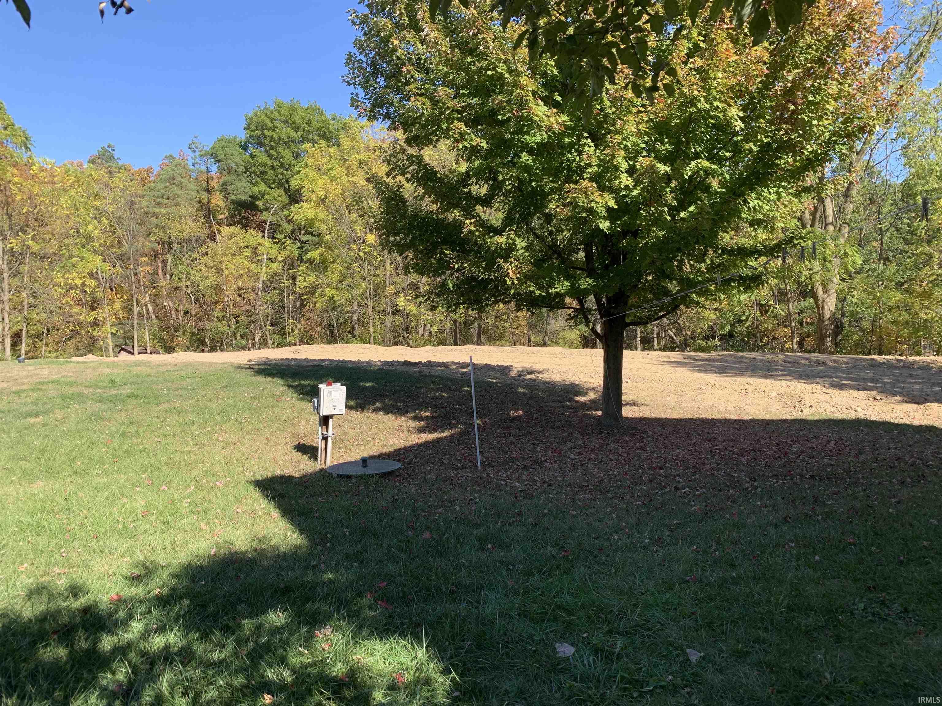 View of green lawn with a wooded view
