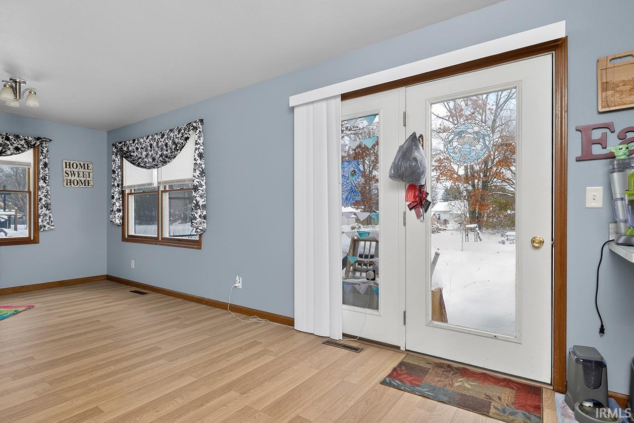 Foyer entrance with light wood finished floors and baseboards