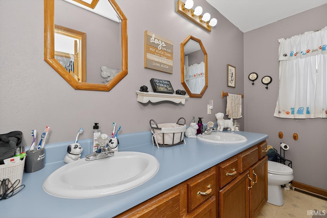 Bathroom featuring double vanity and toilet